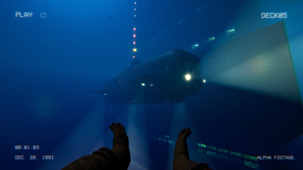 Full Fathom: First-person diver view of a lit submarine near a deck wall with VHS HUD overlay.