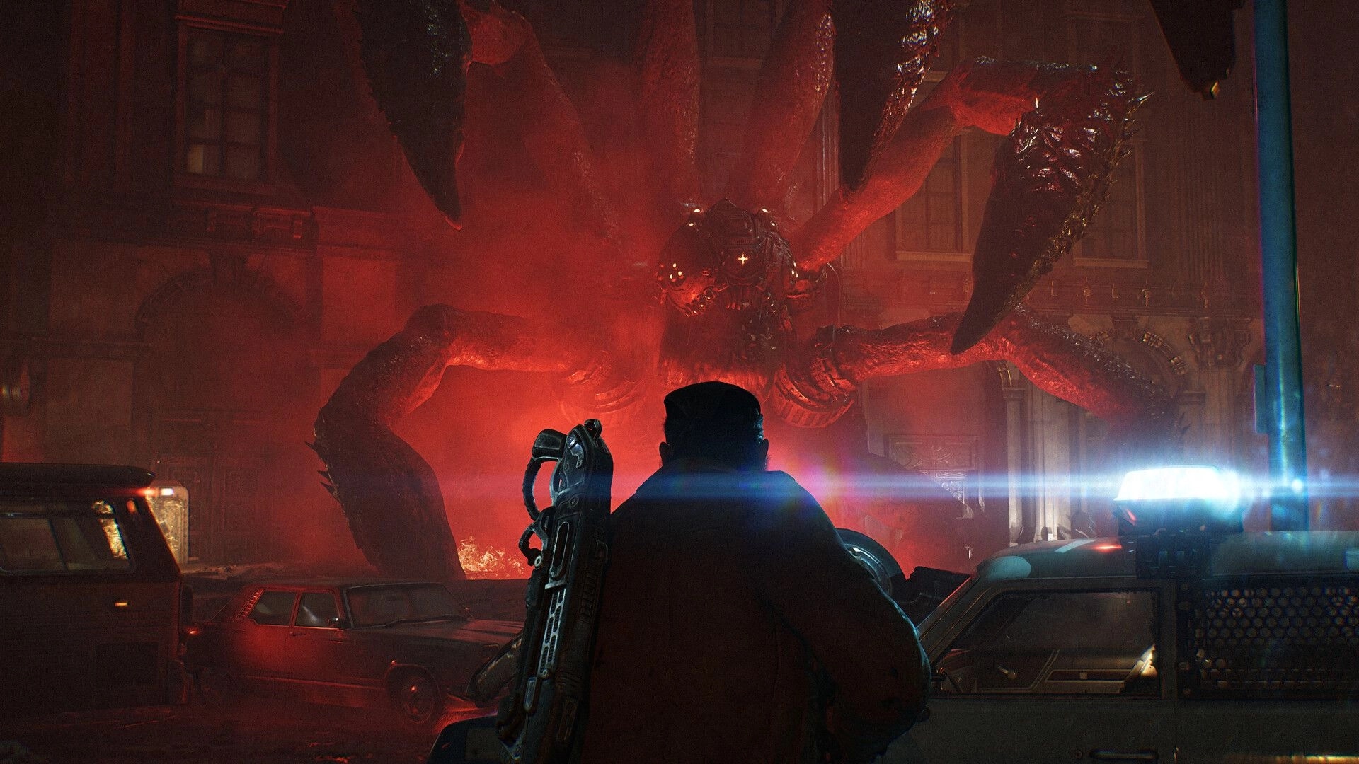 Gears of War: Armed soldier faces giant red tentacled monster amid wrecked cars and city street lights.