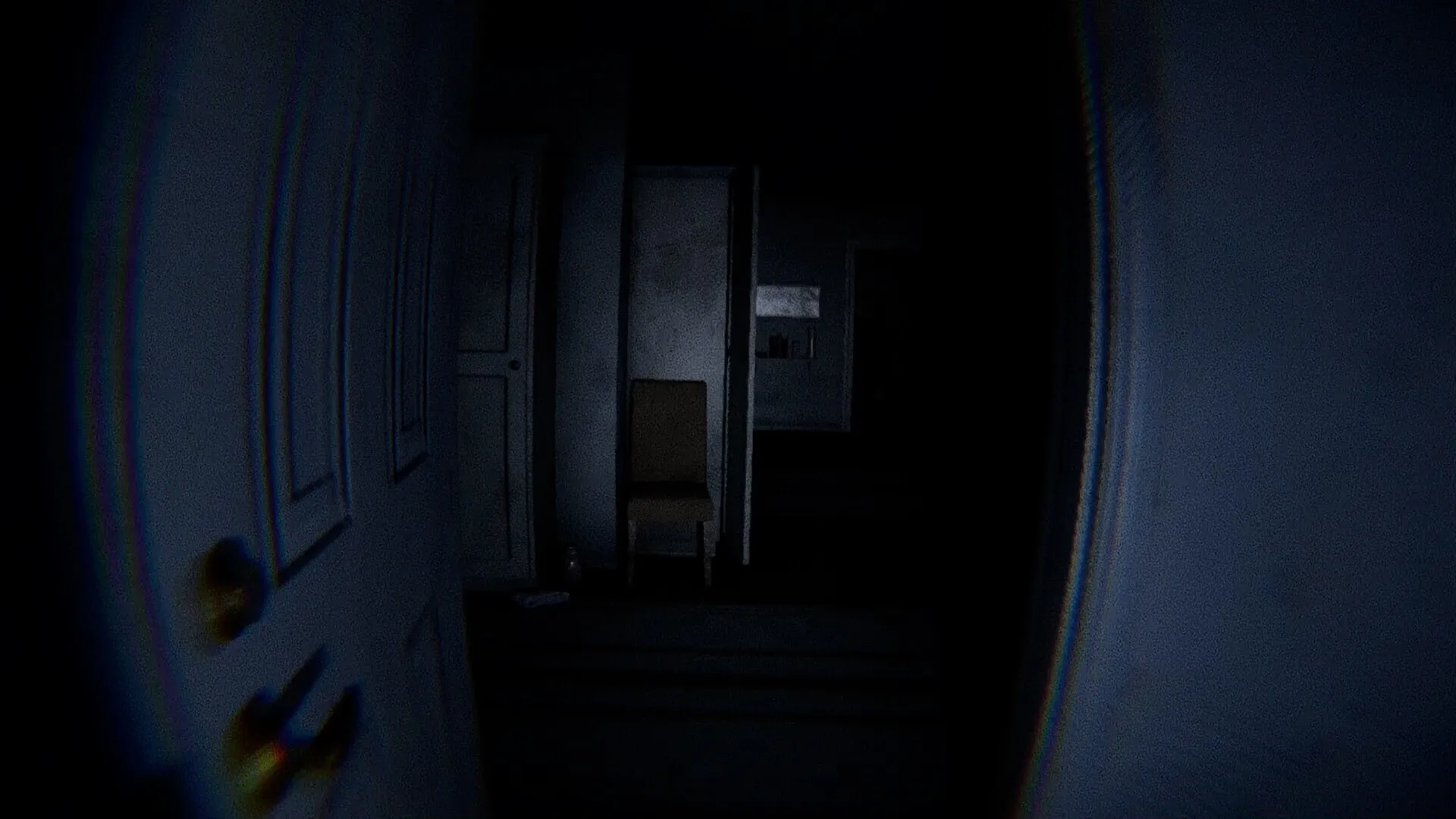 Ghost Frequency: Dimly lit hallway with closed door and a lone chair beside a shadowy wall