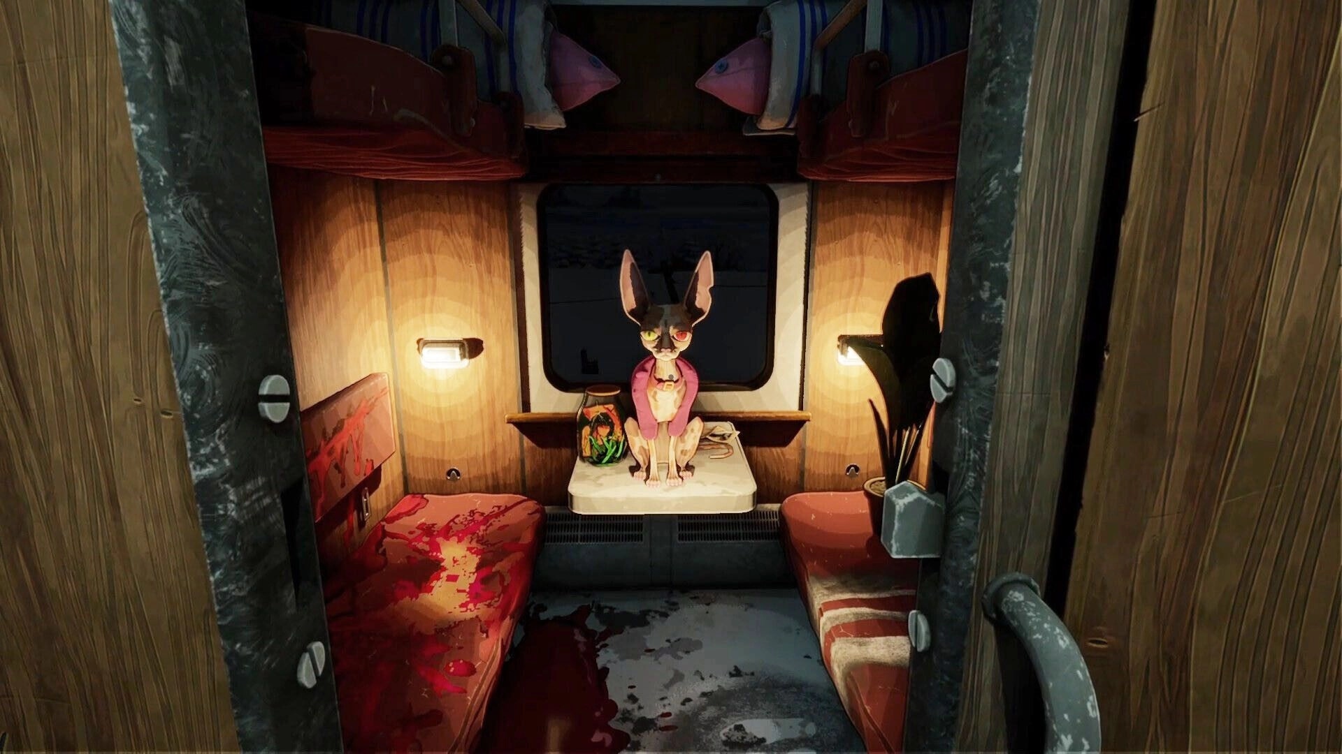 Going my way?: Cat-like passenger sits on a table between bunks inside a dim train cabin.