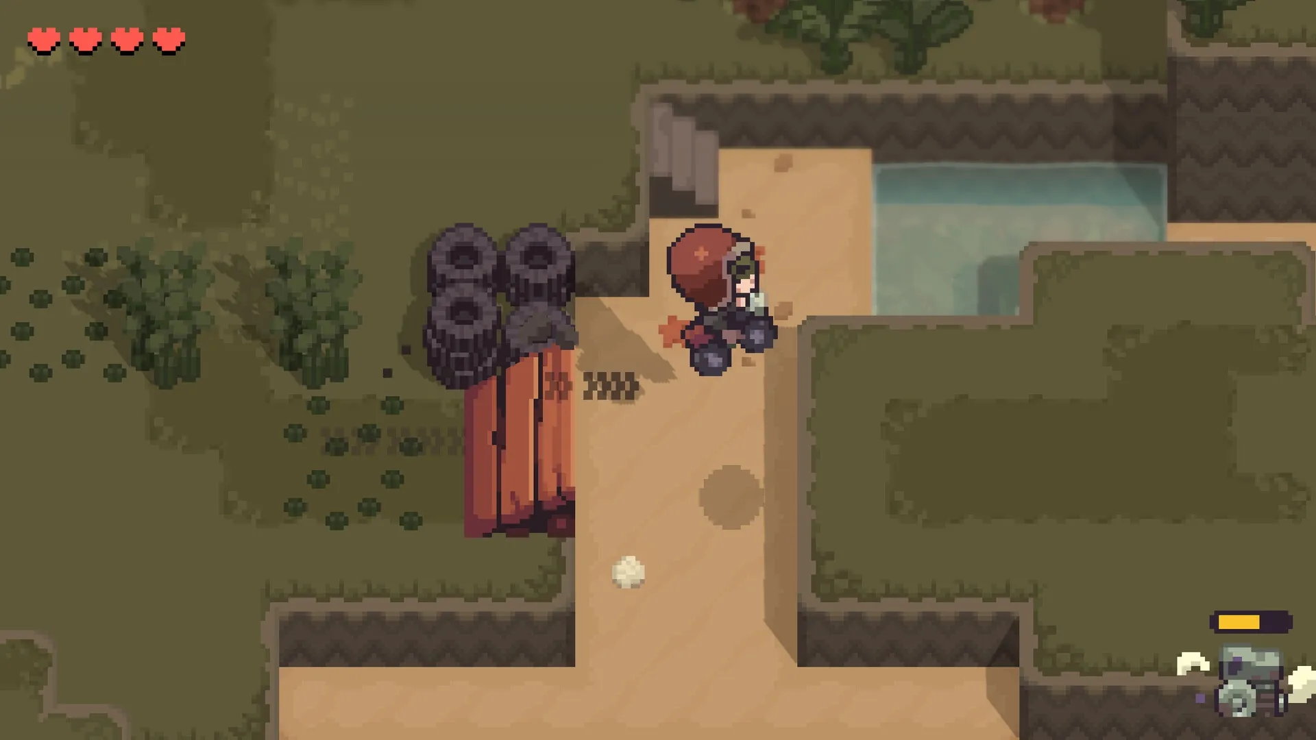 Graytail: Character in red hood explores sandy path near water with health hearts displayed in corner