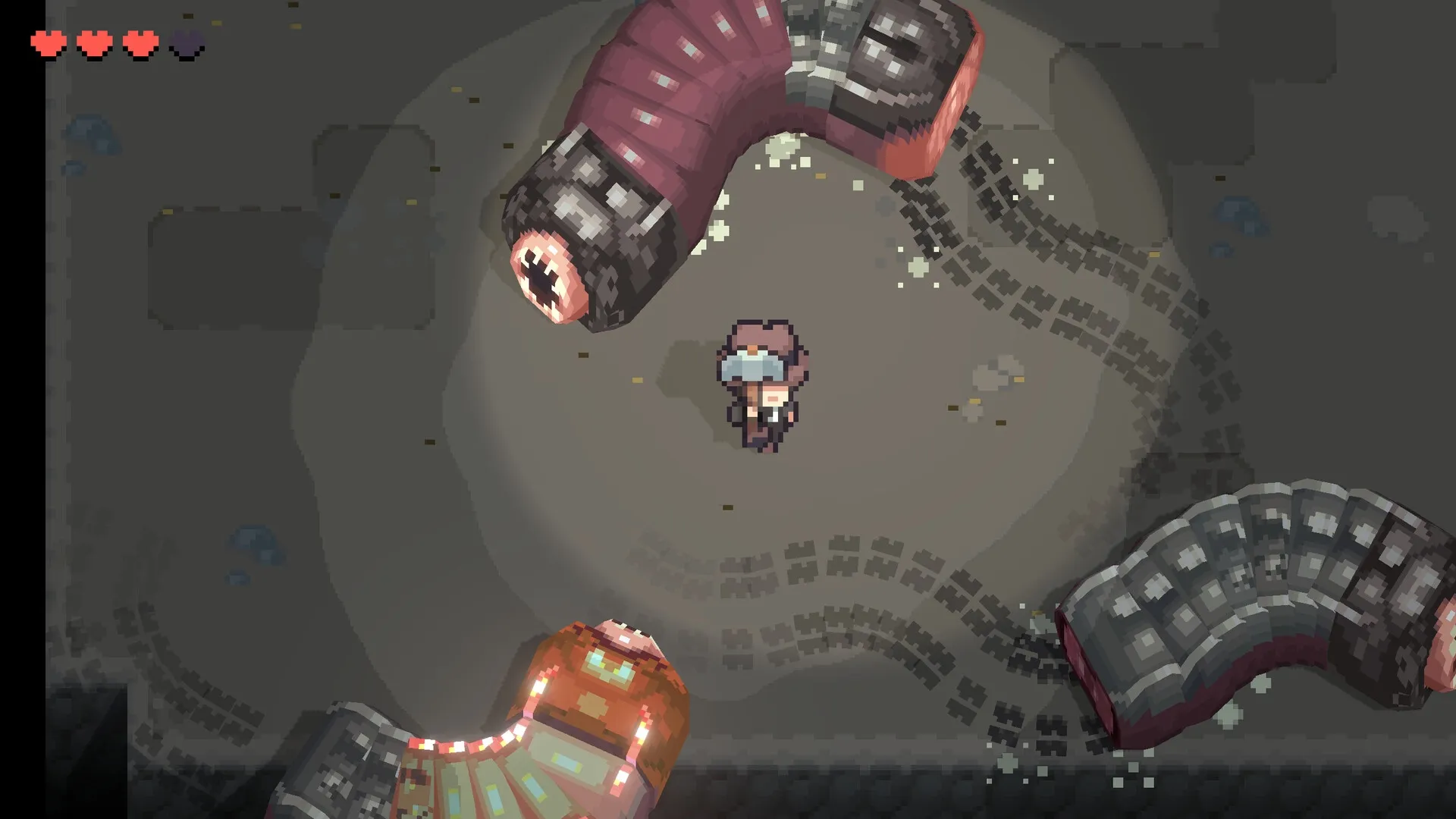 Graytail: Character facing giant segmented worm in dark cave with health hearts in top left corner
