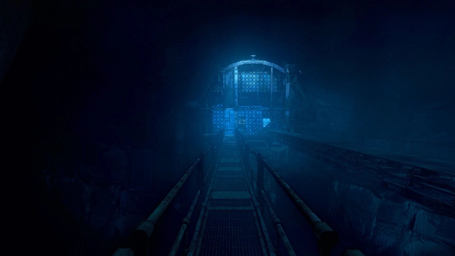 Hoarder: Foggy first-person view down a metal catwalk toward a caged platform in blue darkness.