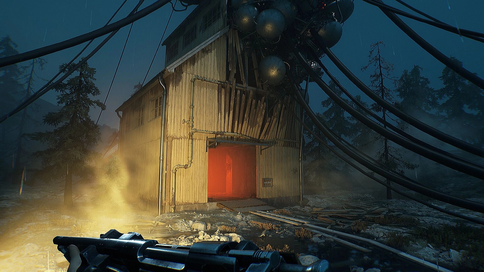 INDUSTRIA 2: Player holds weapon approaching eerie building with cables in foggy forest setting