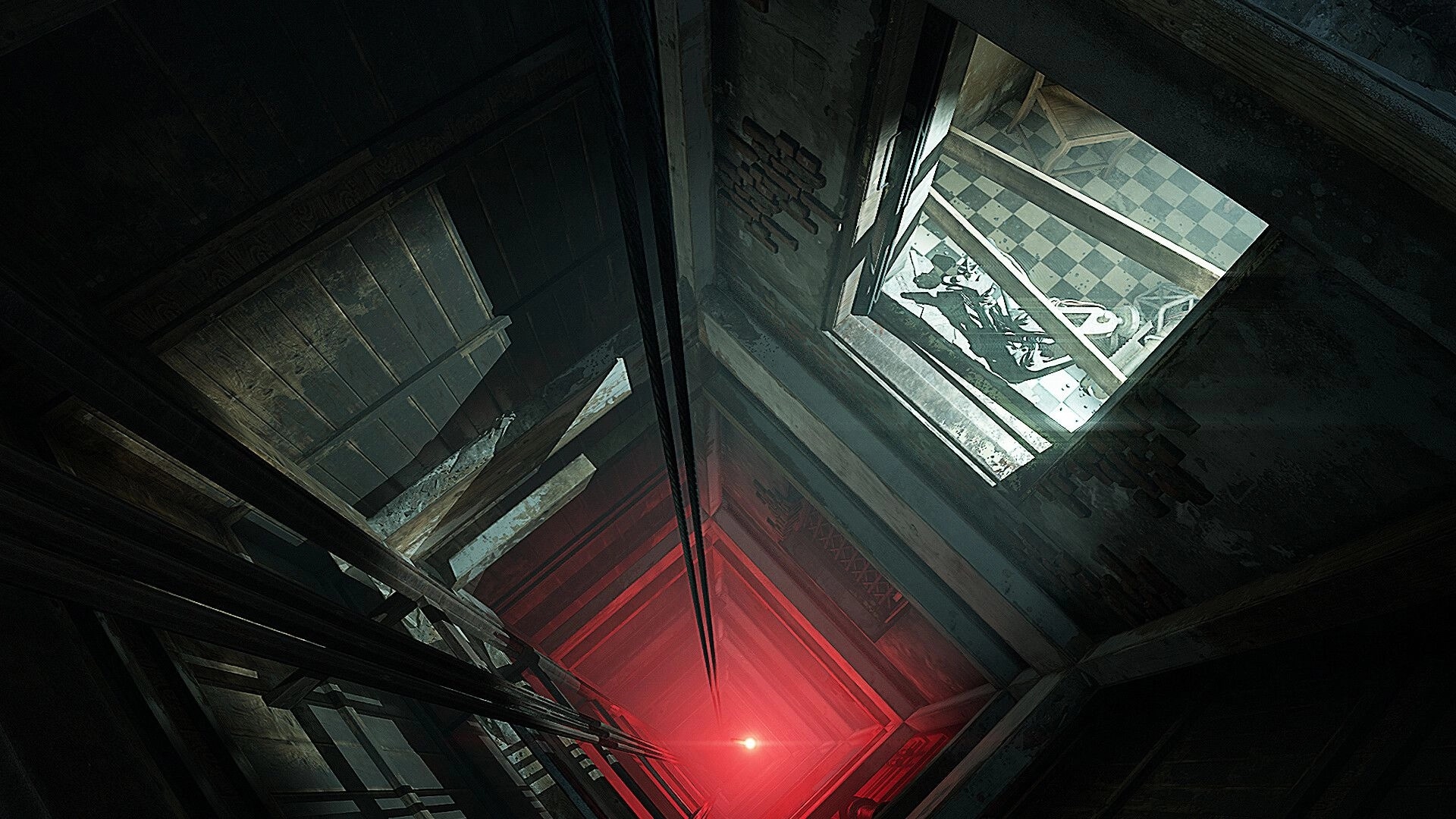 INDUSTRIA 2: Looking down a red-lit elevator shaft with a view of a checkered floor room above