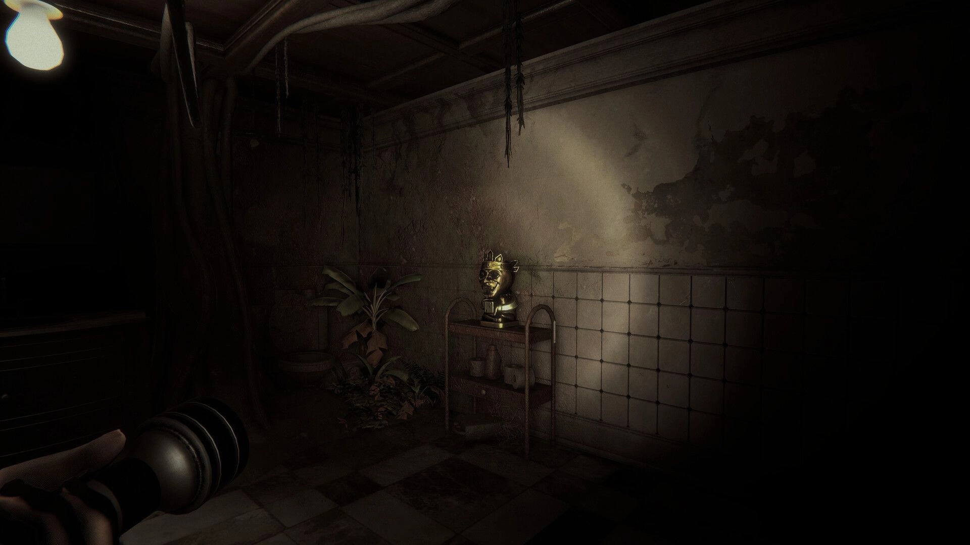 Invokyr: First-person view aiming a flashlight at a gold idol on a shelf in a grimy tiled room.