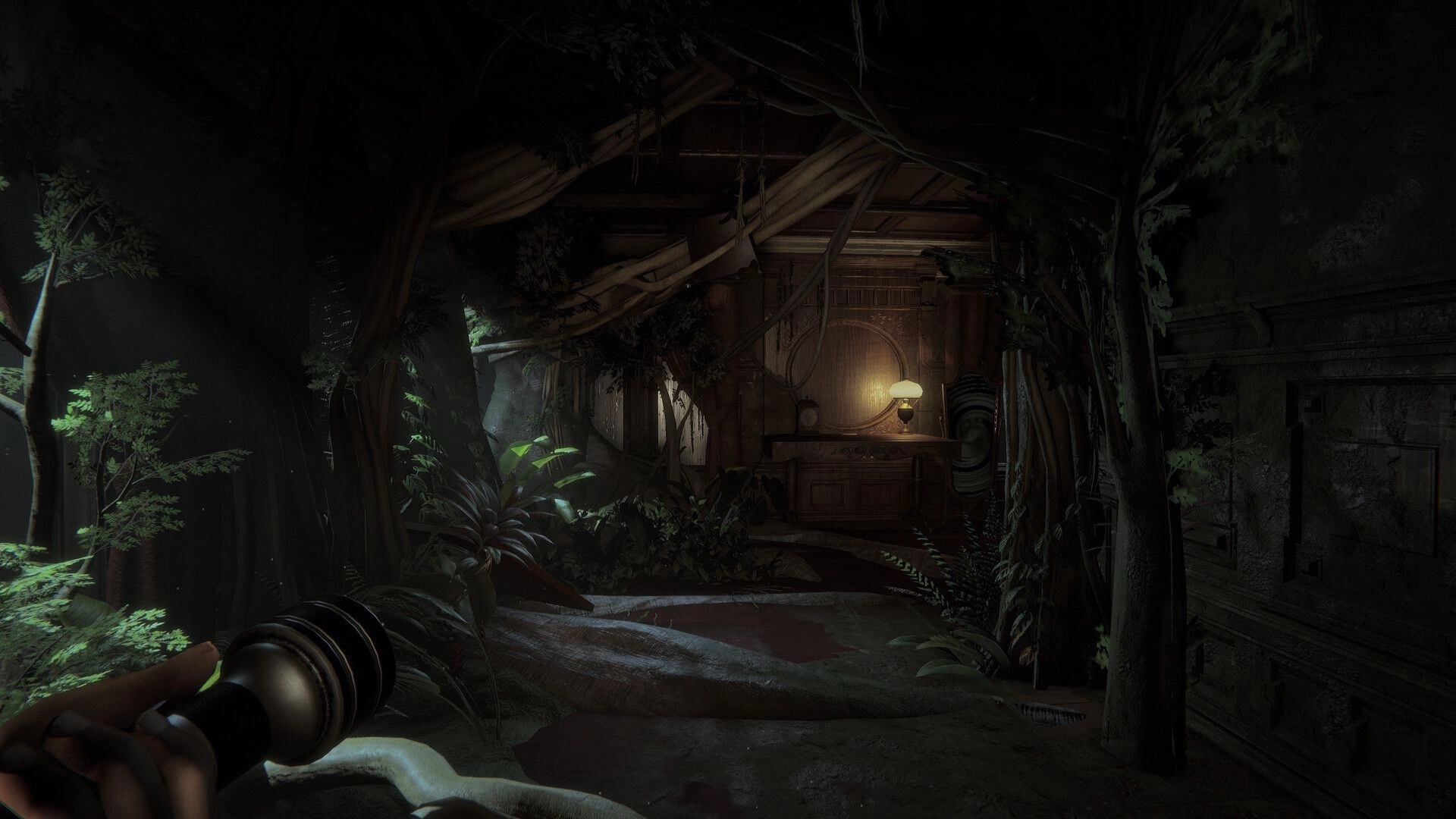 Invokyr: First-person view holding a flashlight in an overgrown hallway with vines and a lit lamp.