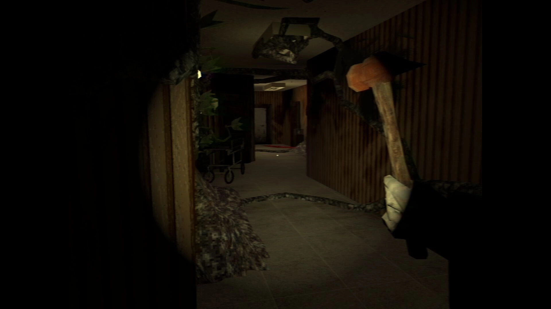 It Breathes: First-person view holding a hammer in a dark hospital corridor with debris and gurney.
