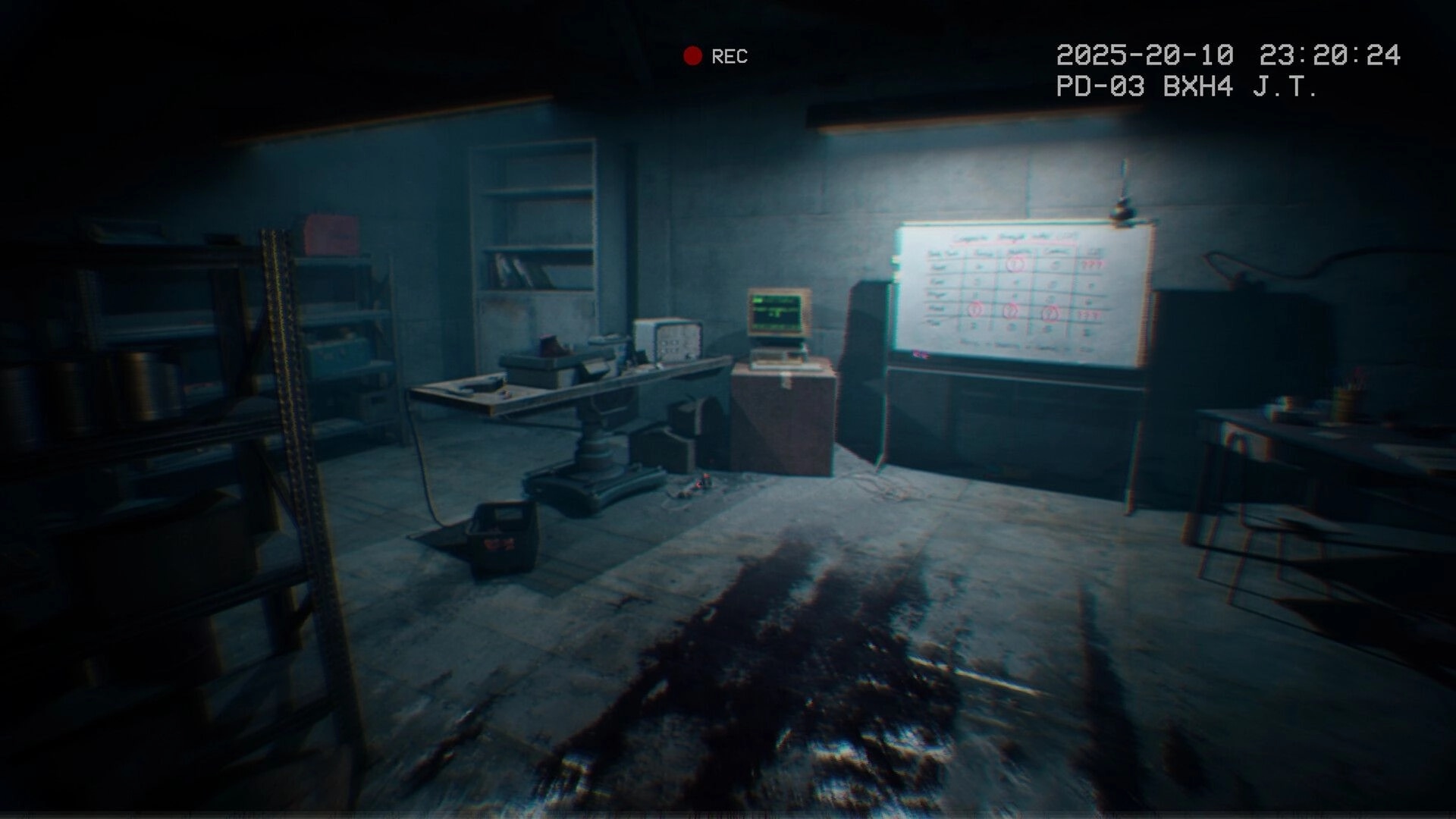 It Reaches: Blood-stained hospital room with old computer, whiteboard, and surveillance timestamp.