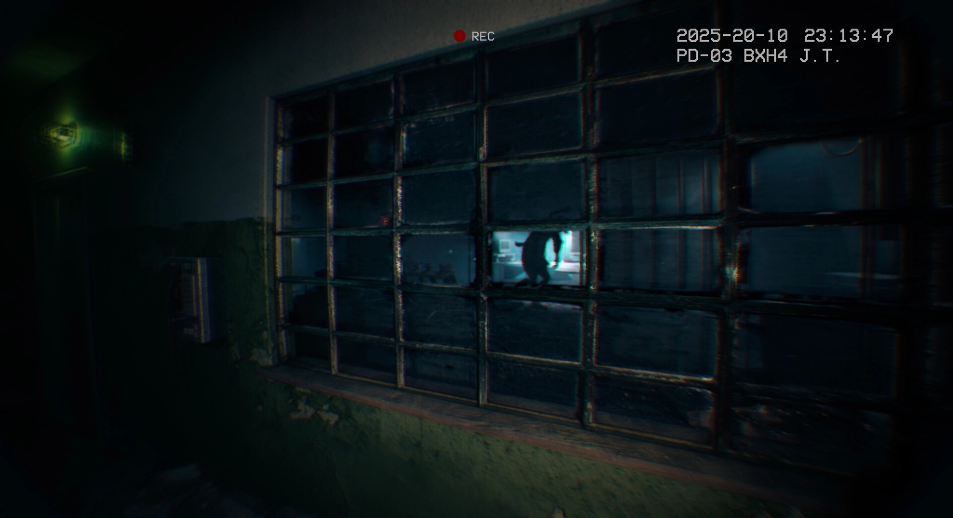 It Reaches: Shadowy figure moving inside a dimly lit abandoned hospital hallway, seen through glass window