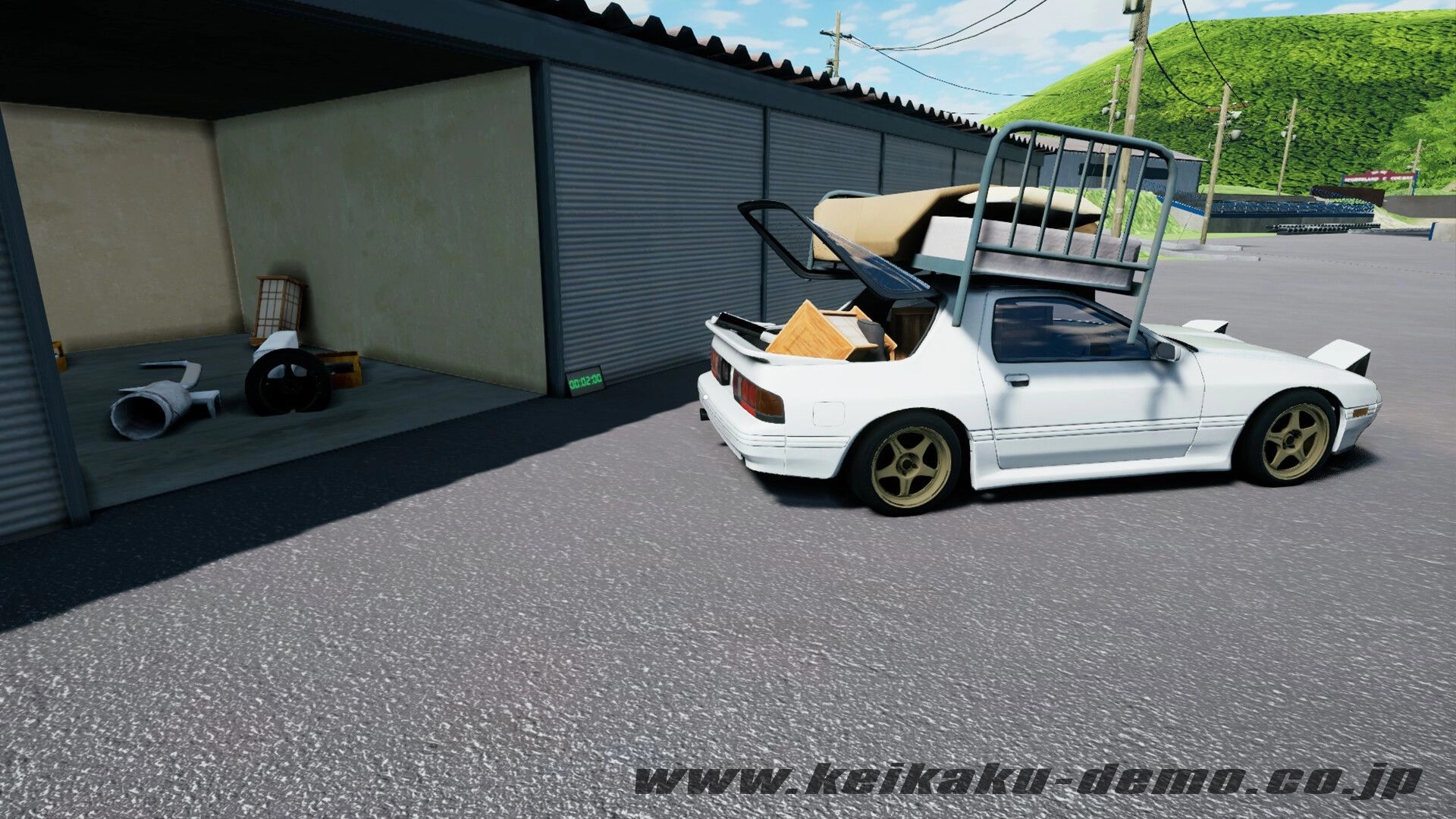 Keikaku計画: White coupe loaded with furniture on roof rack, parked by metal garages and hills.