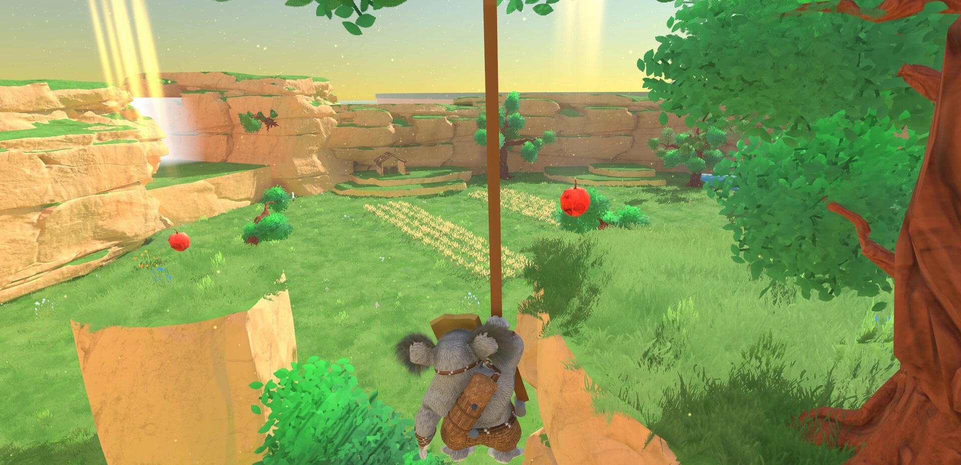 Koromi: Koala-like character climbs a vine above a grassy canyon with red fruit and cliffs ahead.