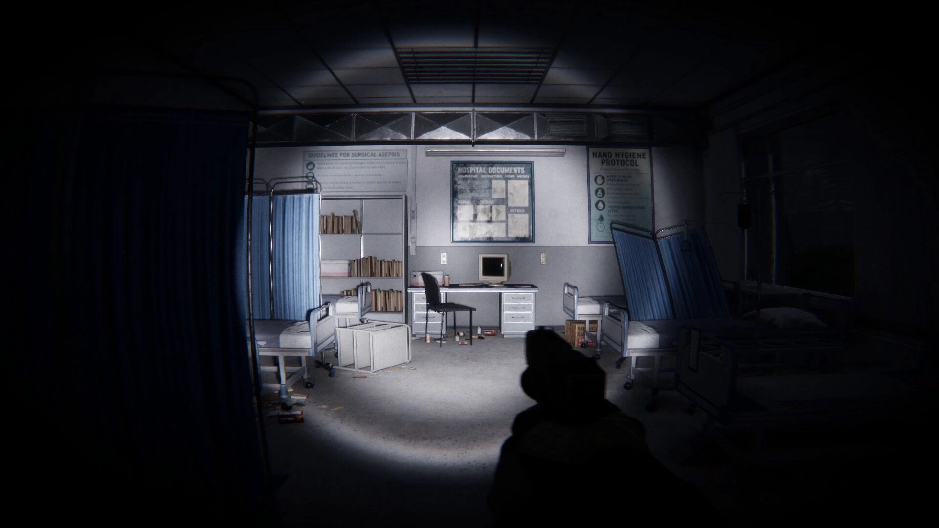 Lens Of Fear: Flashlight aiming at hospital beds and desk with old PC in a dim clinic room.