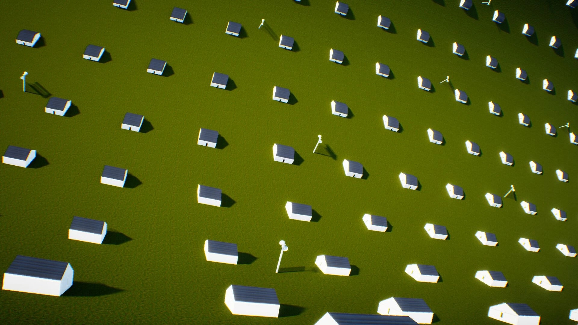 LIMINOID: Aerial view over scattered small white houses on a green field under harsh sunlight.