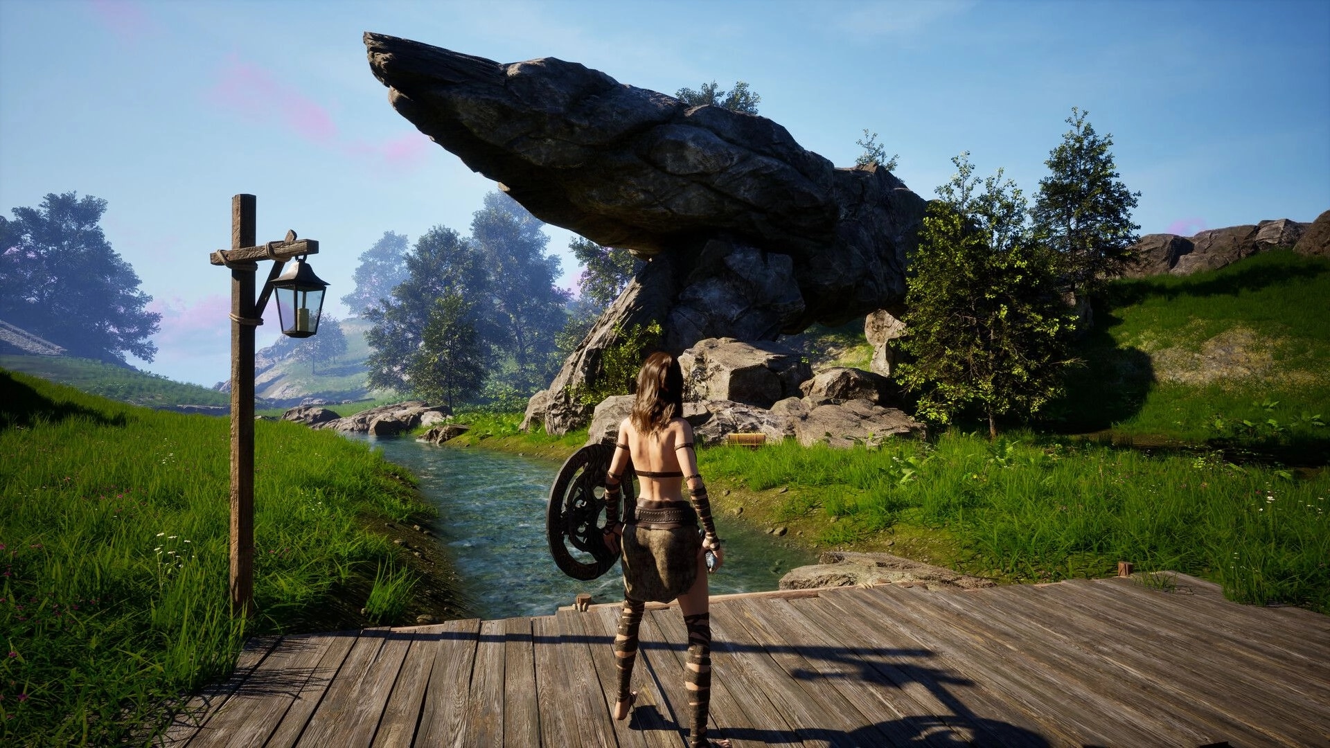 Luminary: Third-person warrior with shield on wooden dock by stream beneath towering rock outcrop.