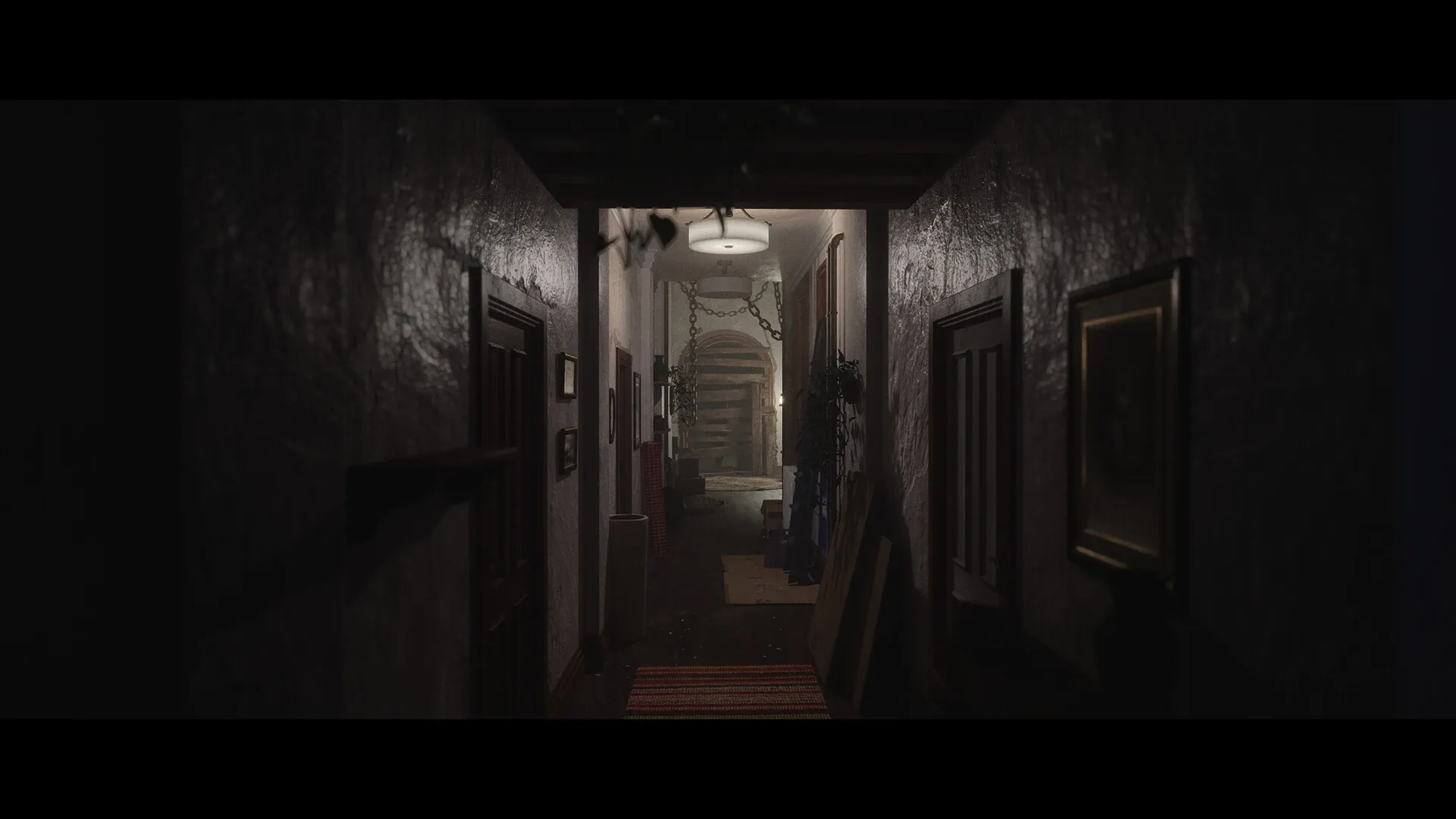 Luto: Dimly lit hallway with chained door and scattered furniture creating a tense atmosphere