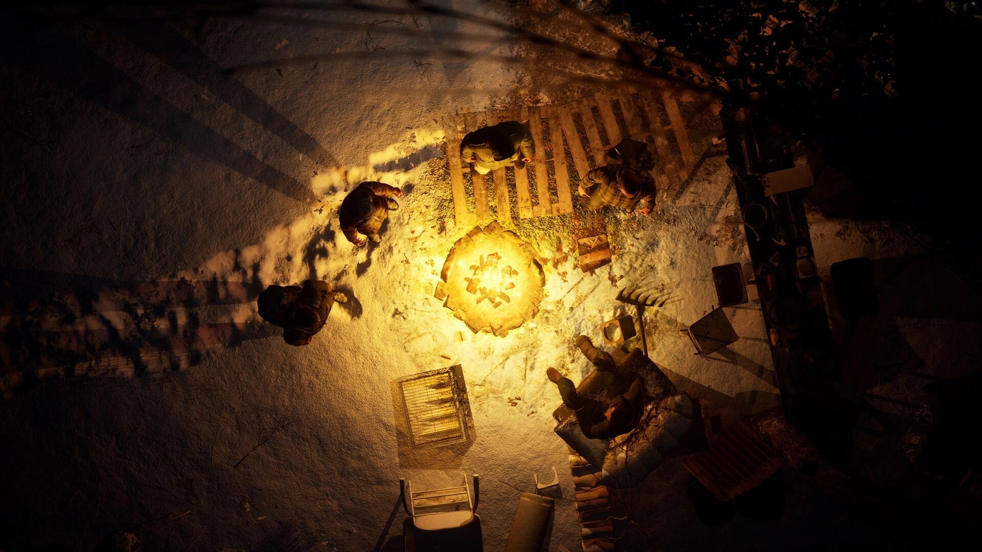 Macabre: Group gathered around a campfire on snowy ground, surrounded by scattered gear and shadows.