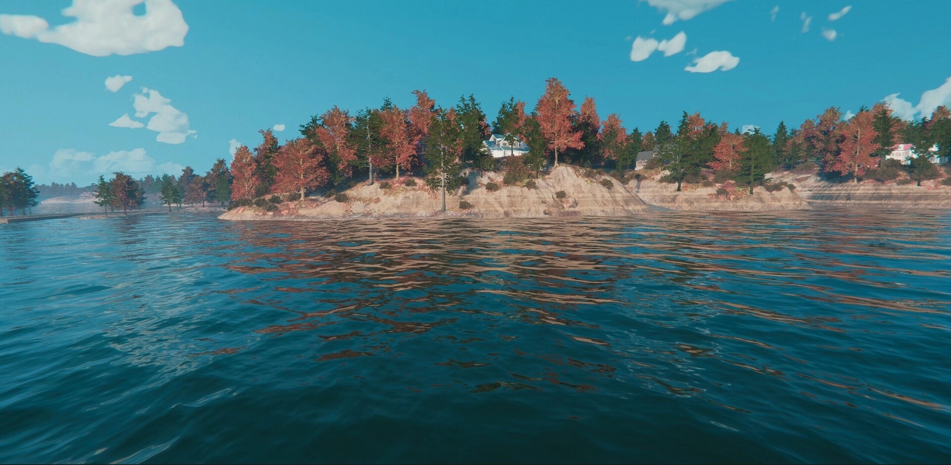 MLF: Open-water view toward rocky shoreline with autumn trees and lakeside houses under blue sky.