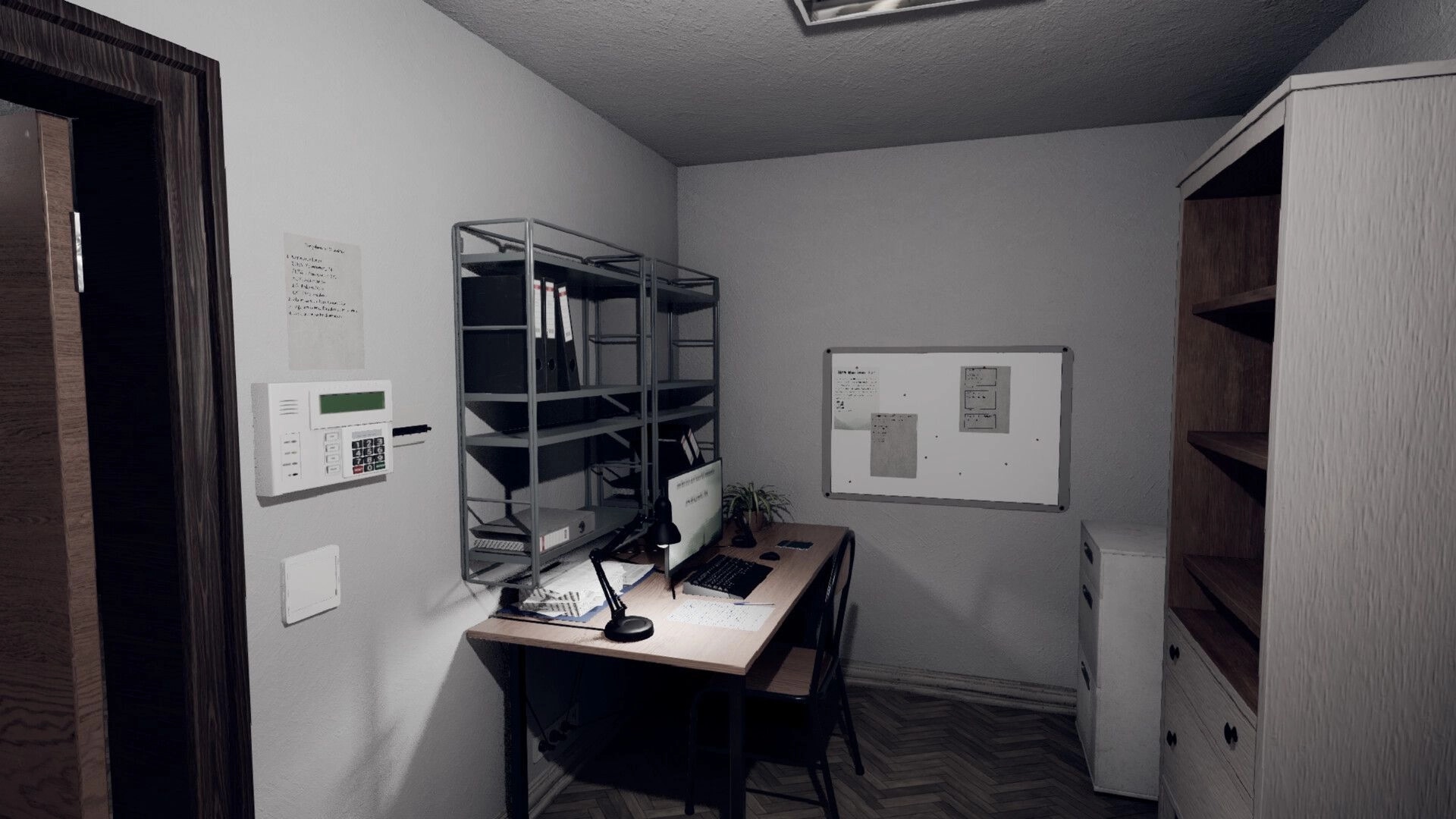 Nachtschicht: Office desk with computer, lamp, and shelves; whiteboard and keypad on wall.