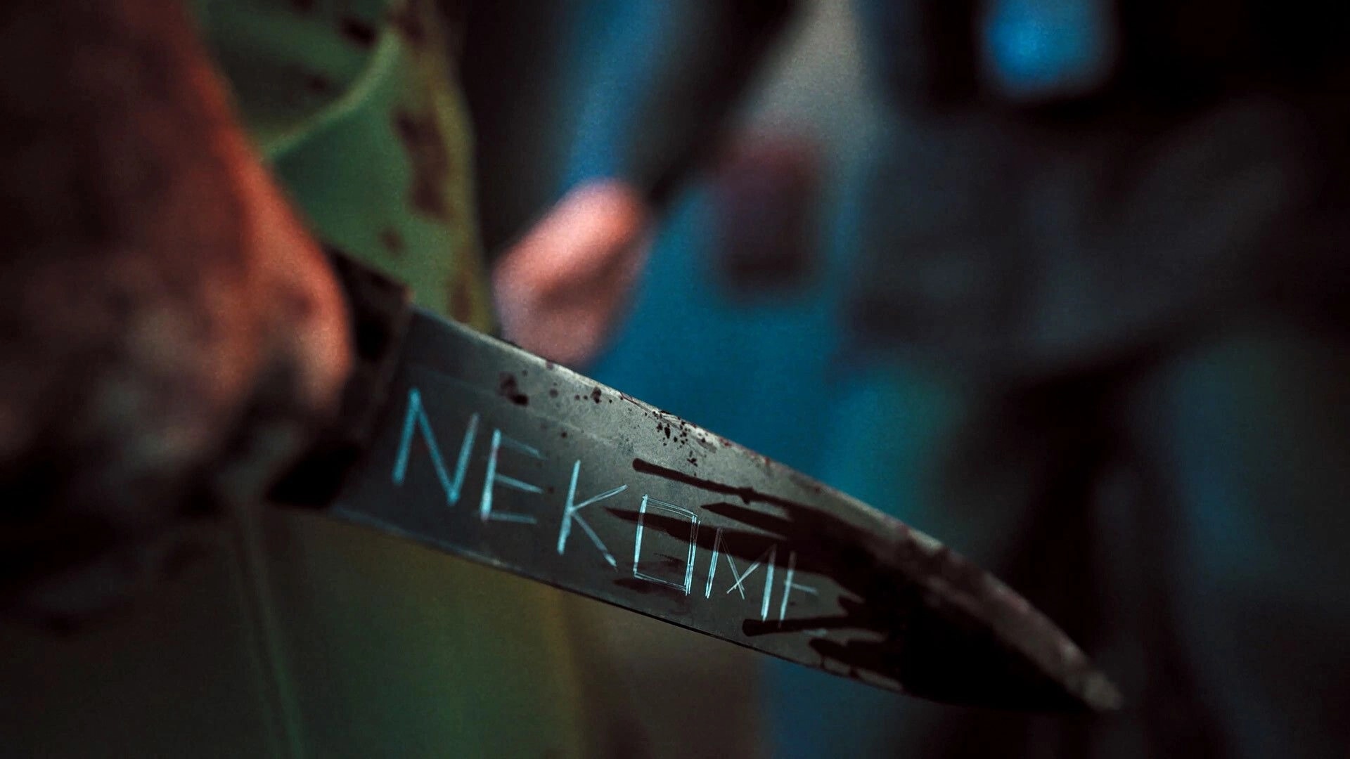 Nekome: Close-up of a blood-stained knife etched with “NEKOMI” in a blurred indoor scene.