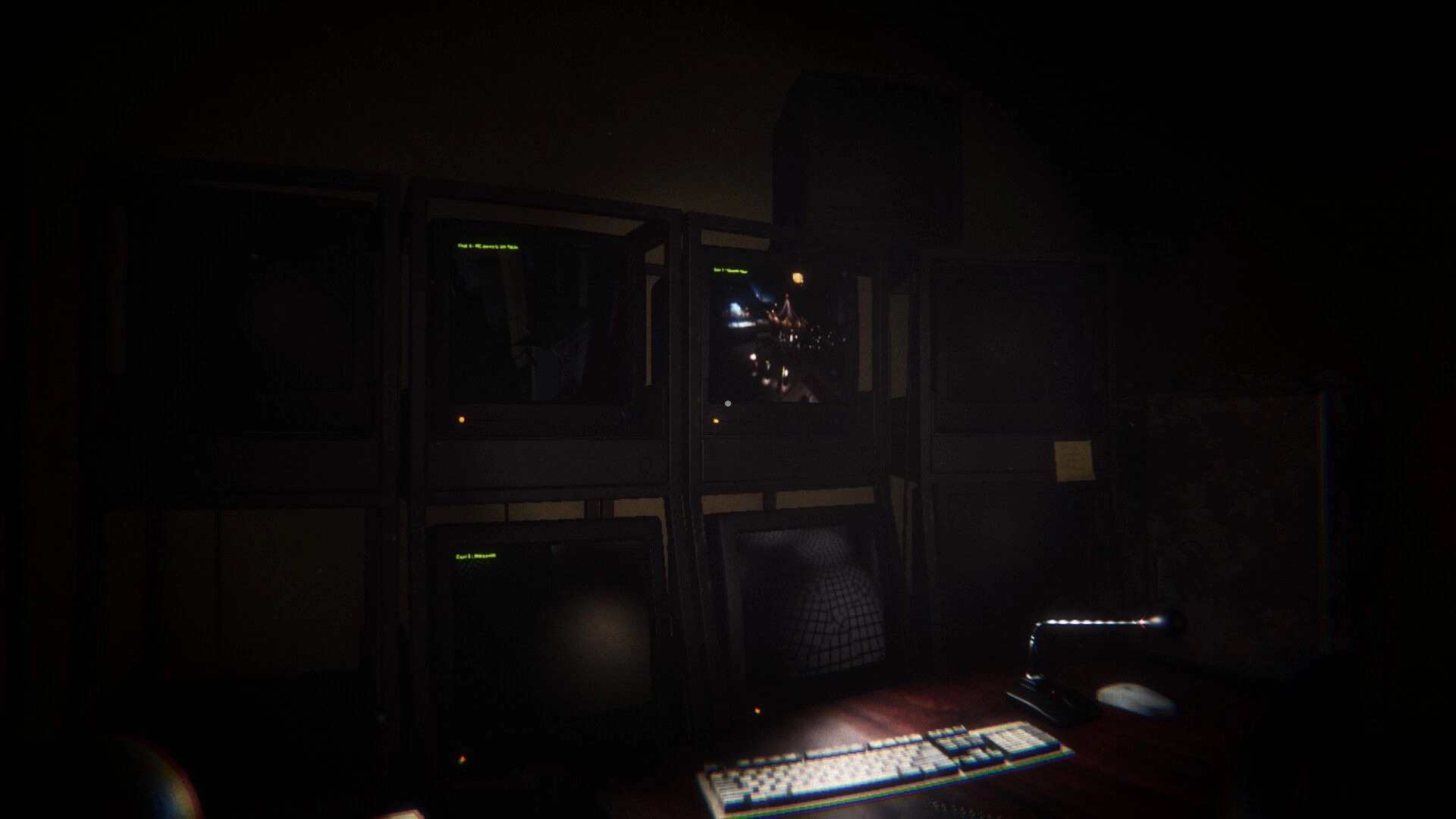Night At The Mall: Security office with multiple dark monitors and a dimly lit desk lamp.