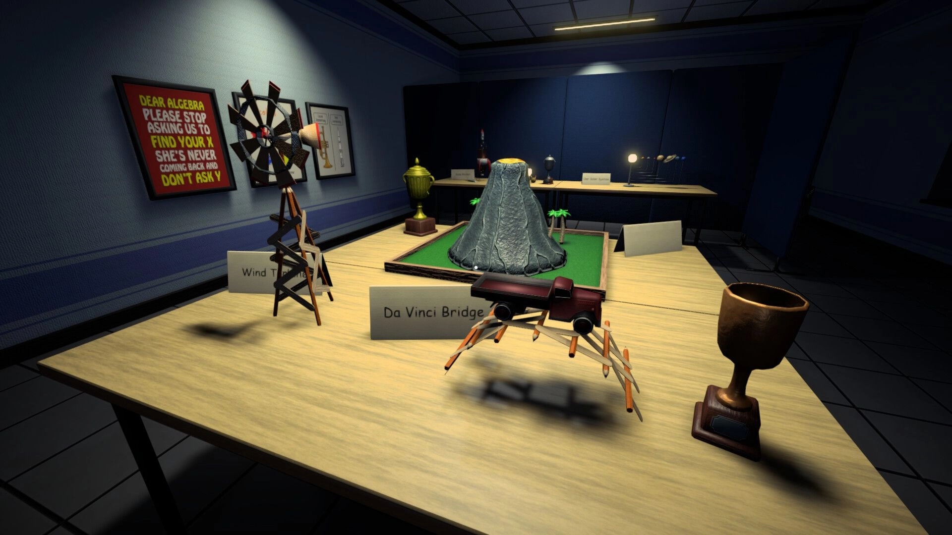 Night Errors: Classroom science exhibit table with Da Vinci Bridge model and volcano diorama under lamps.
