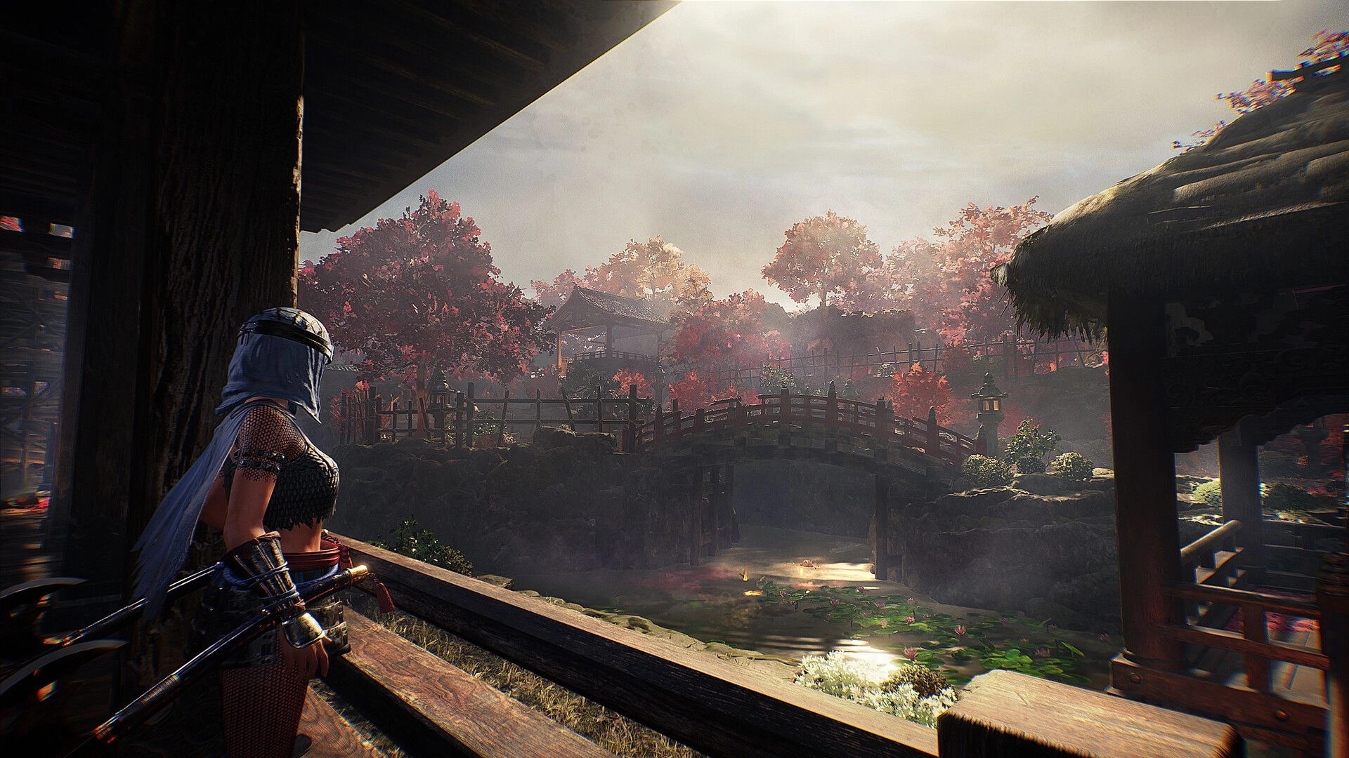 Nioh 3: Female warrior overlooks a serene village with a wooden bridge and vibrant autumn trees.