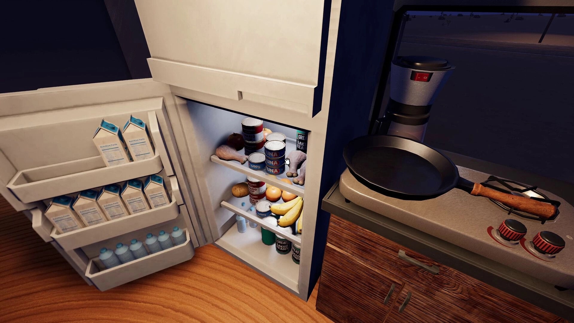 Nomad Drive: Open RV fridge stocked with cans, fruit, and water beside a stove and coffee maker interior.