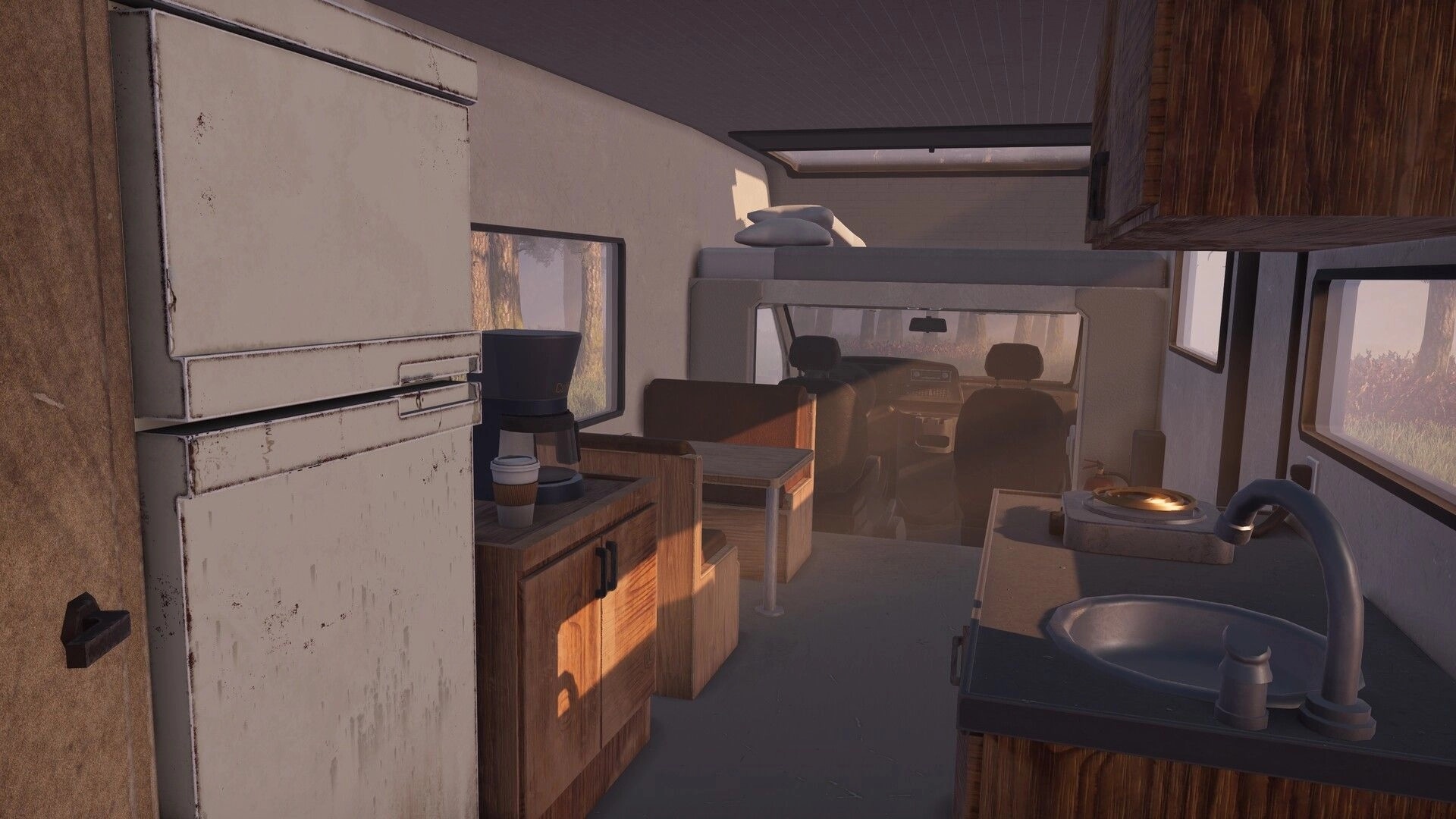 Nomad Drive: RV interior with fridge, sink, coffee maker and bunk bed lit by forest sunrise outside.