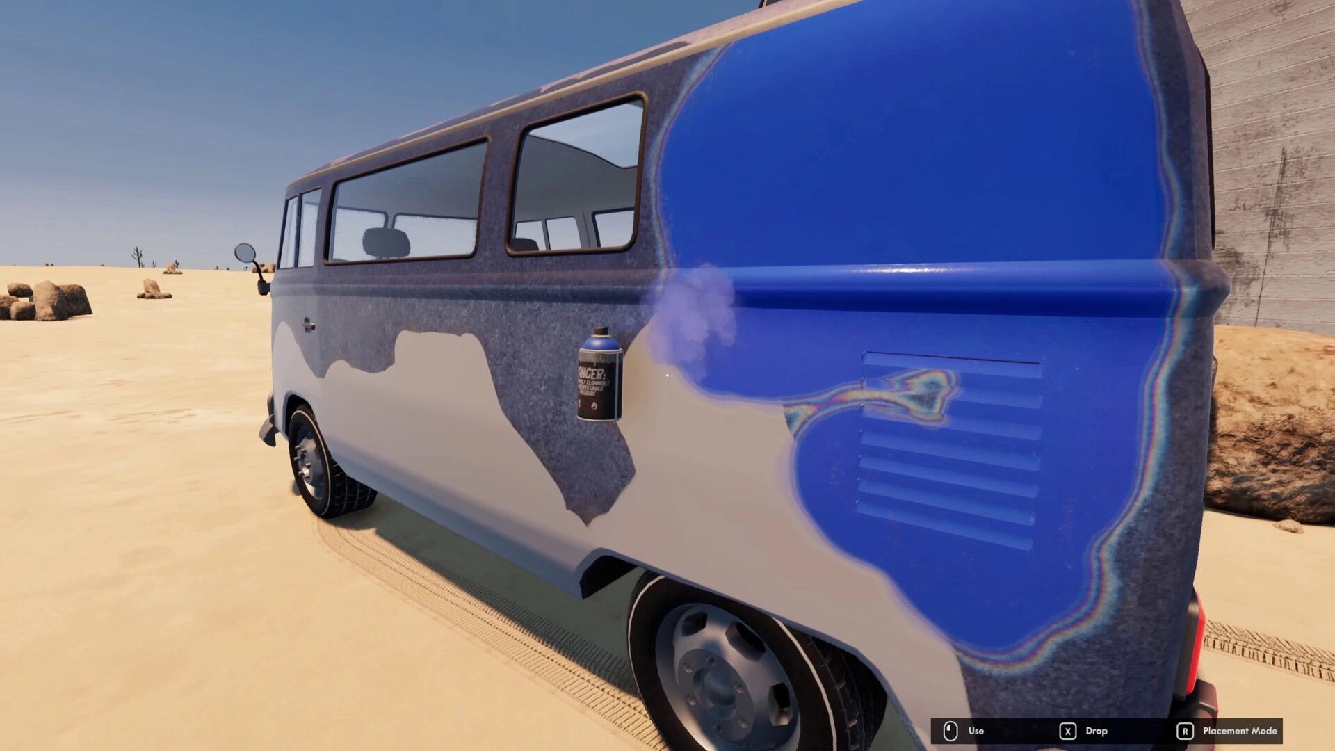 Nomad Drive: Spray painting a blue van side panel in a sandy desert, Use and Drop UI visible.
