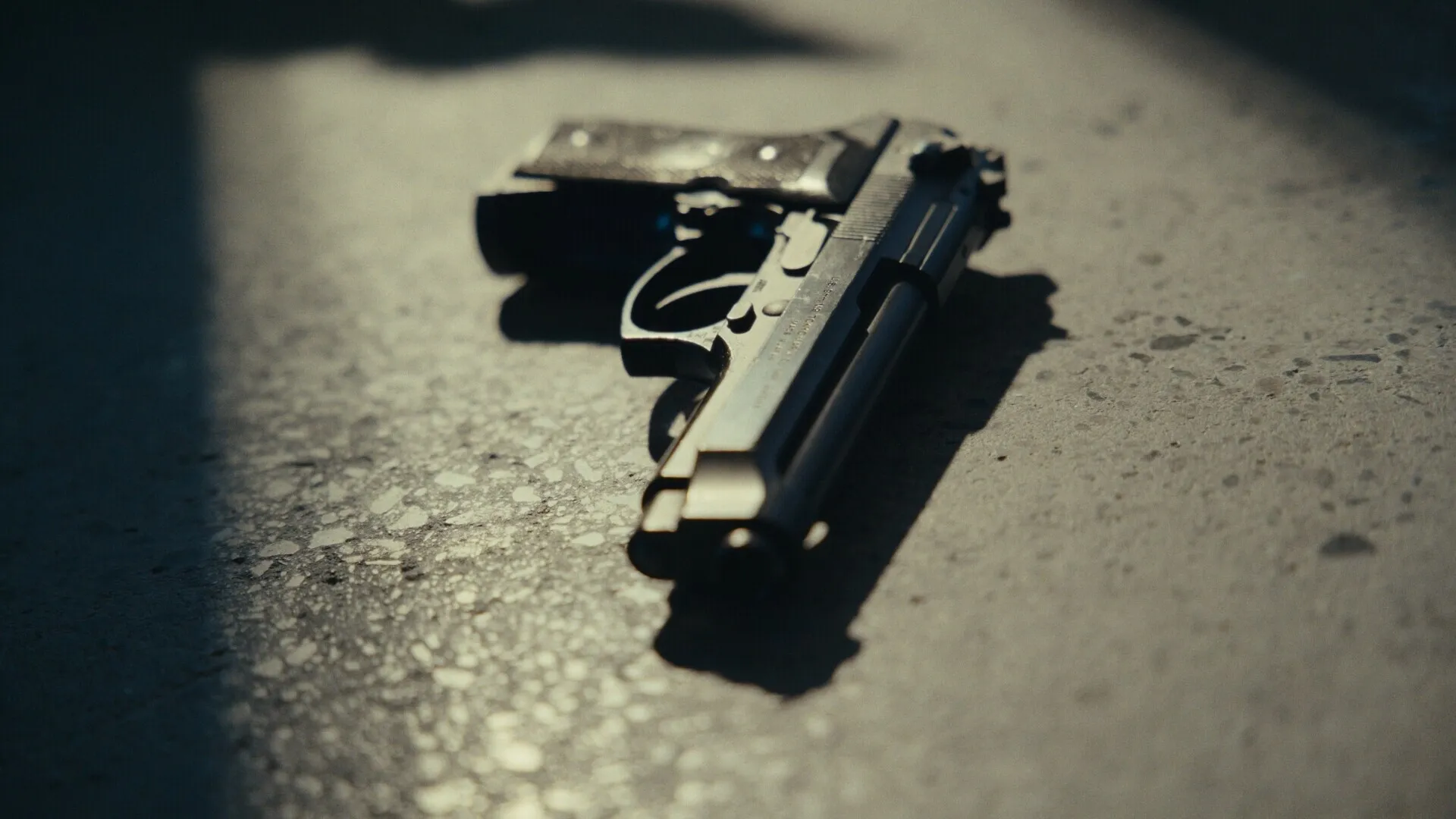 Nowhere to Run: Handgun lying on a dimly lit concrete floor, casting shadows in a mysterious setting