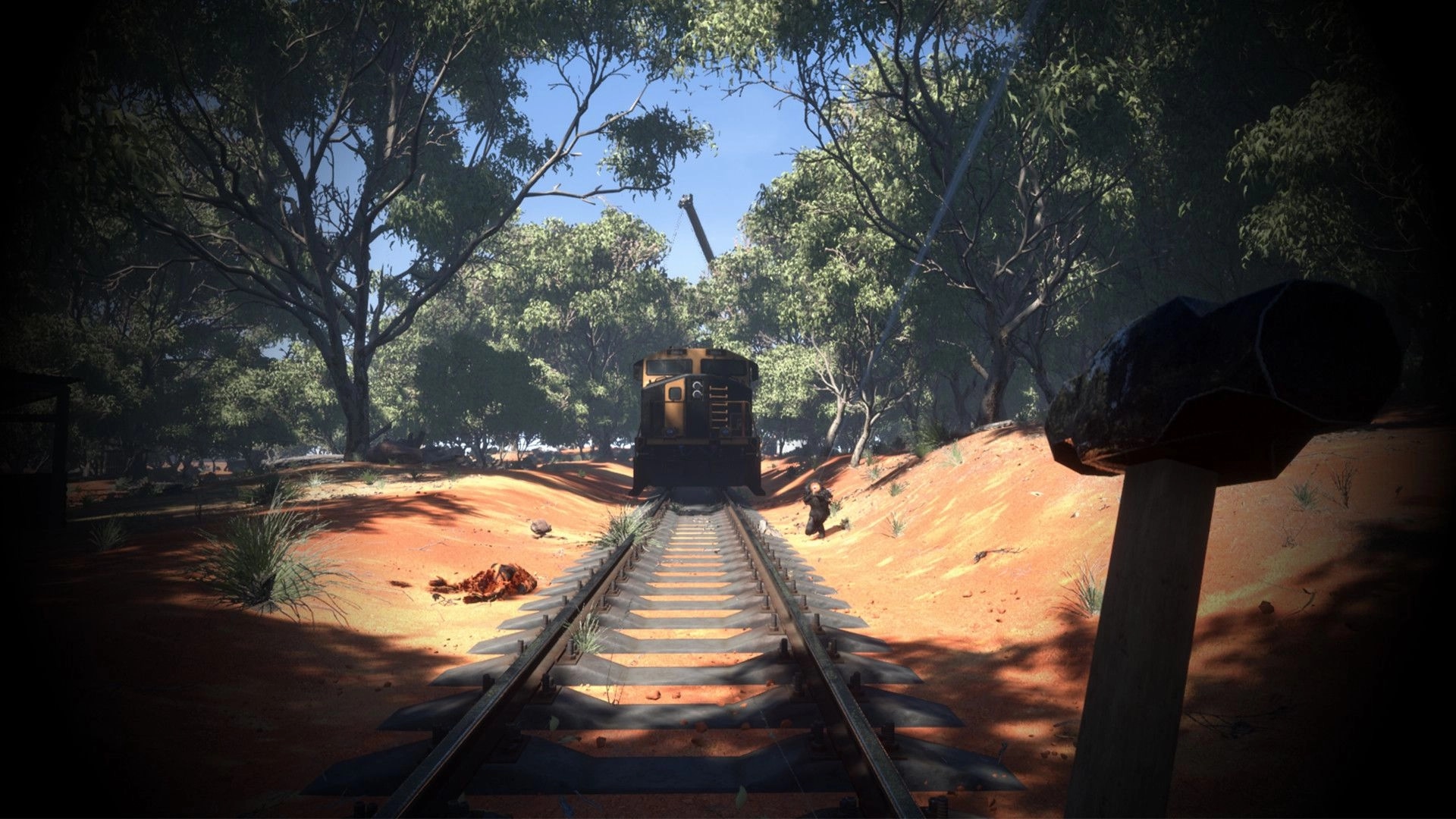Obscurity: Hammer in foreground with train on tracks in a sunlit forest setting