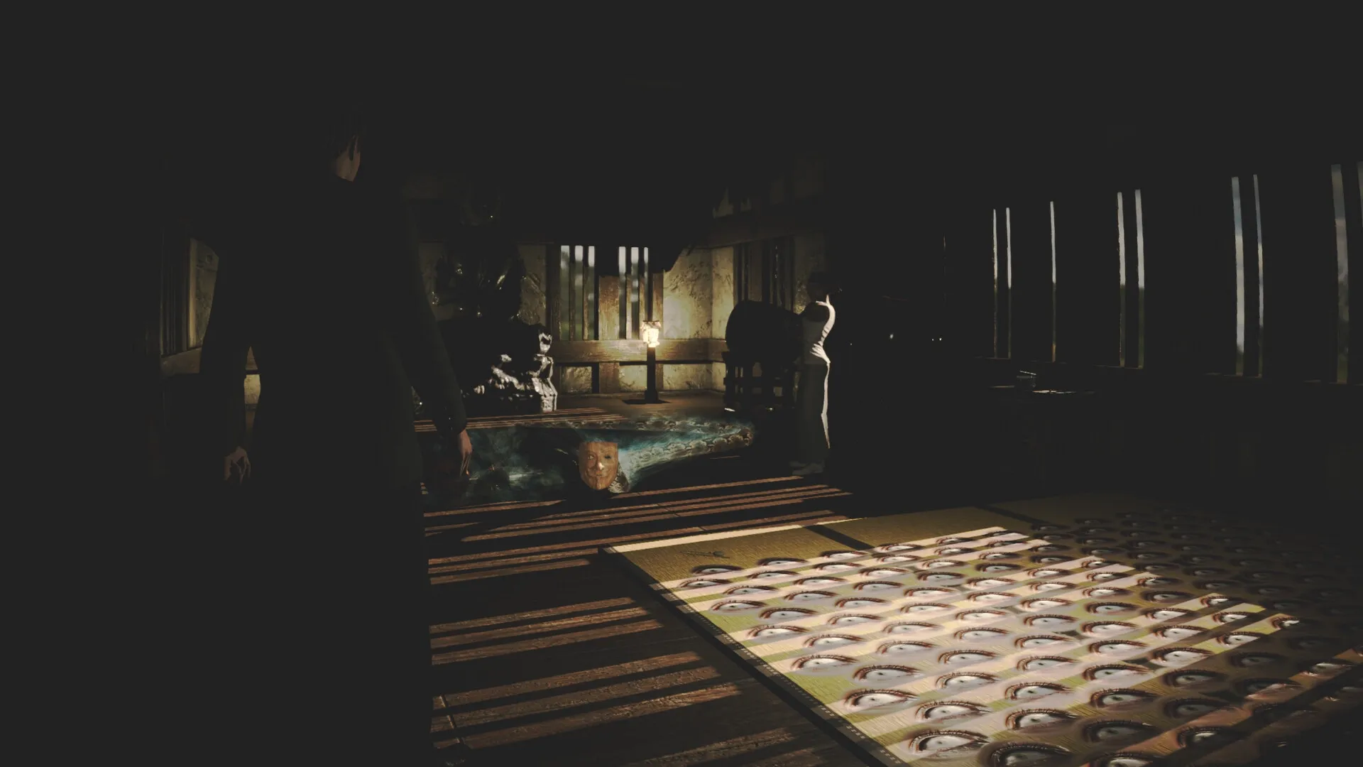Okinawa Journal: Shadowy room with eerie masks on floor, a statue, and a character in dim light