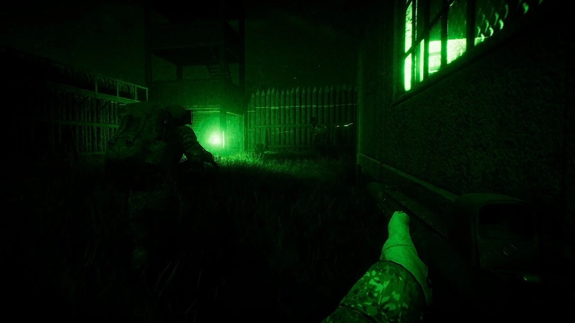 ORMOD: Night-vision first-person player aiming rifle beside teammate in grassy yard by fenced building.