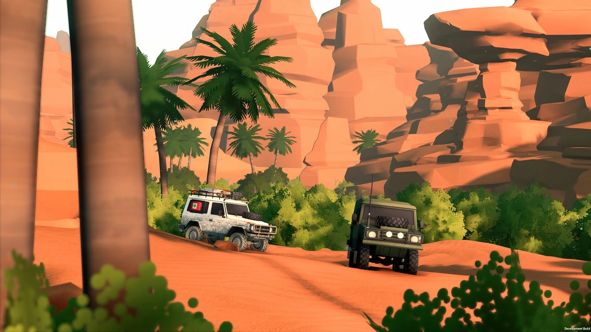 over the hill: two off-road SUVs drive sandy trail past palm trees and towering red canyon cliffs.