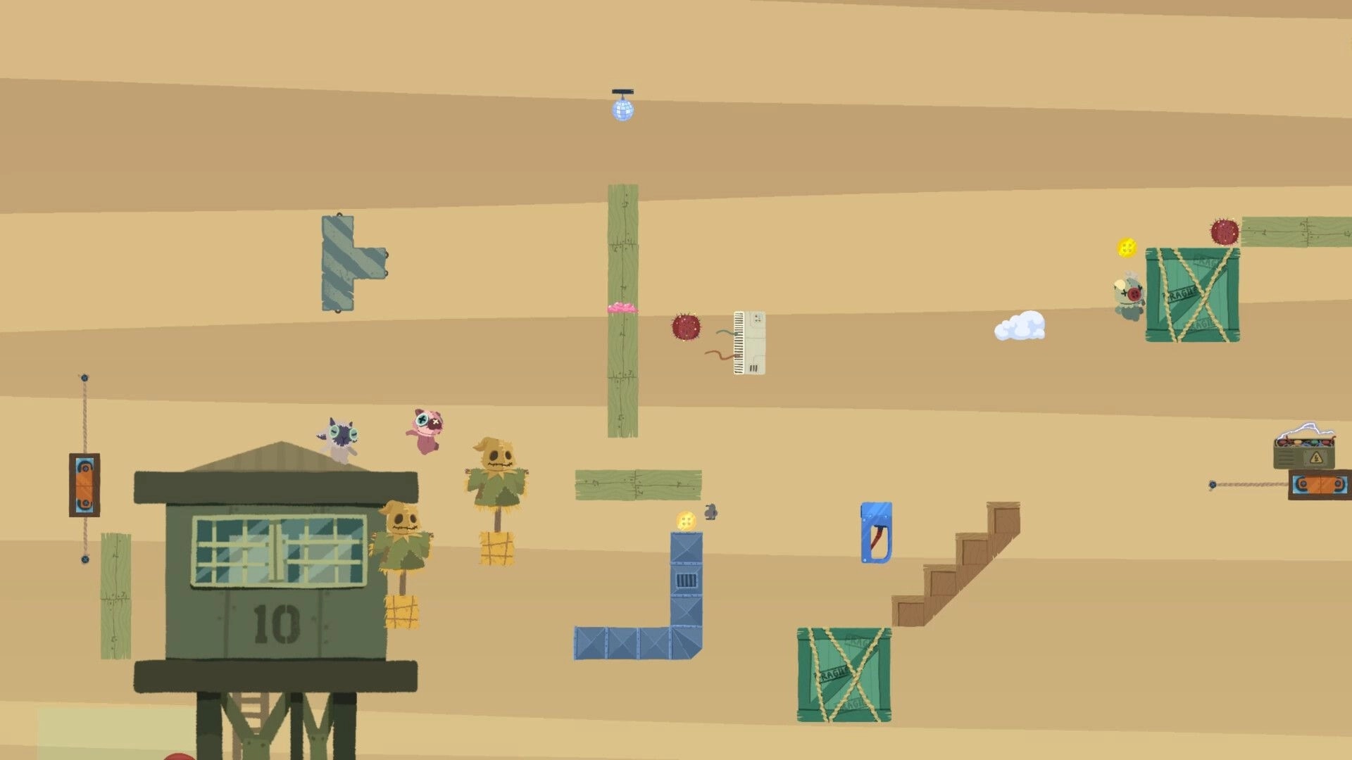 Patchkins Party: Two patchwork racers leap over platforms and hazards in a sandy workshop arena level.