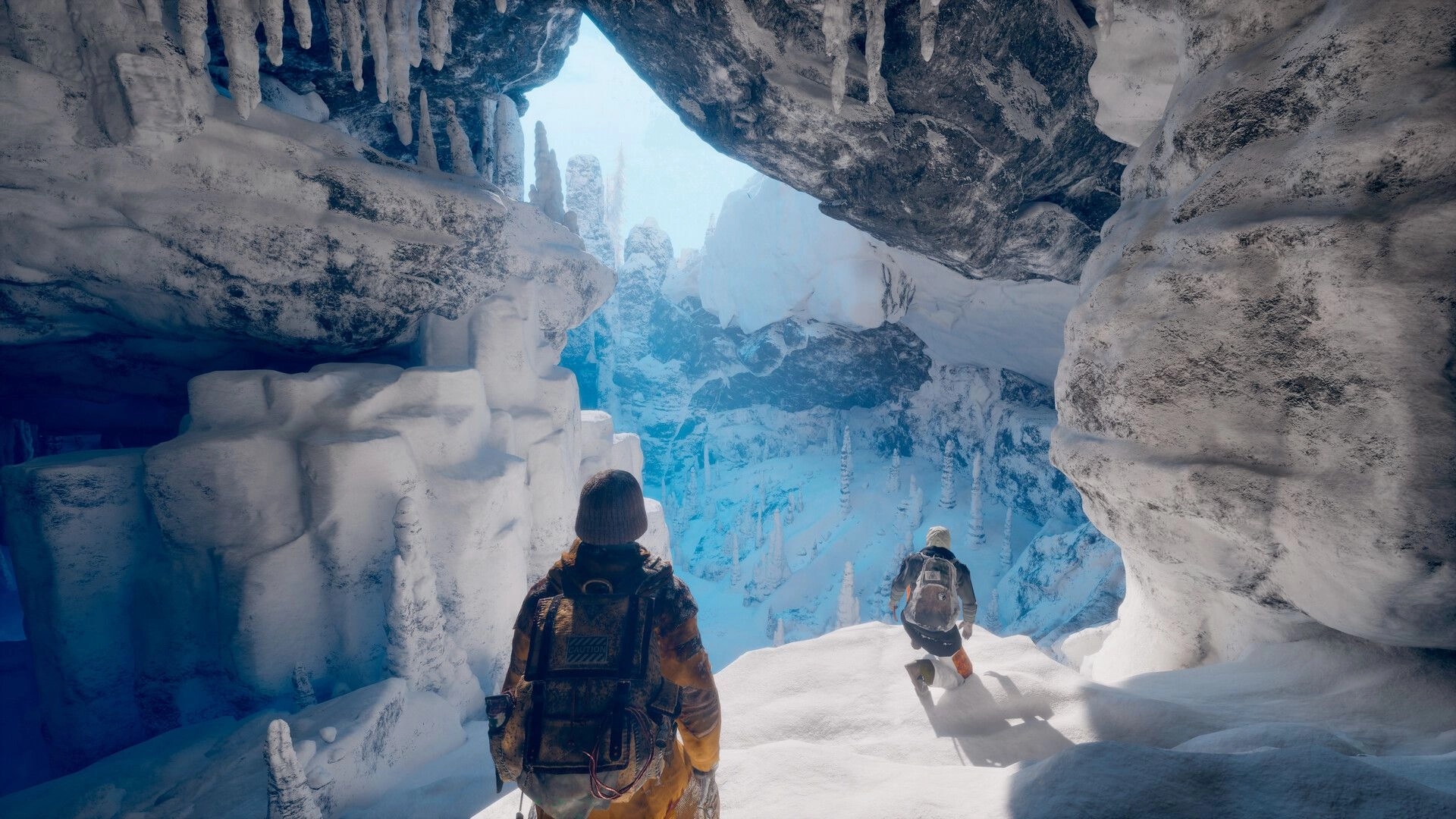 Permafrost: Two explorers navigate an icy cave with stalactites and a snowy mountain vista beyond.