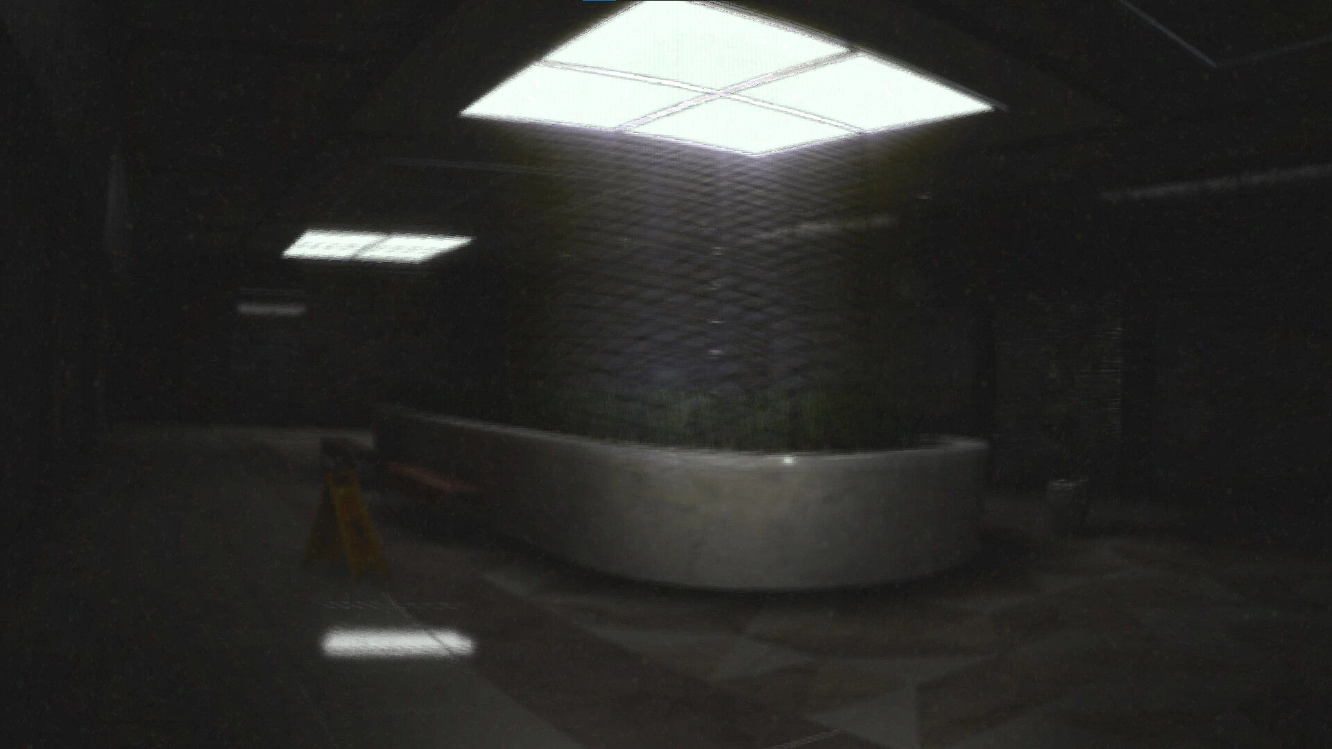 Project Liminal 2: Dimly lit hallway with overhead lights and a caution sign in eerie, dark setting
