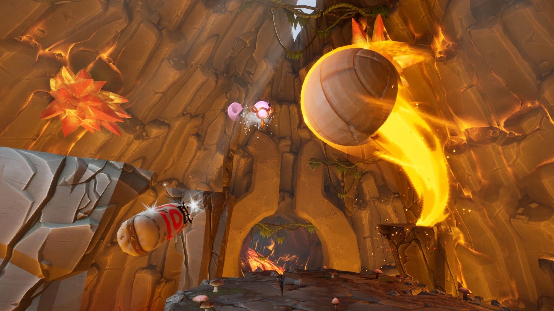 Prop Sumo: Flaming spinning top prop battles a pink balloon in a rocky cave arena with orange crystals.