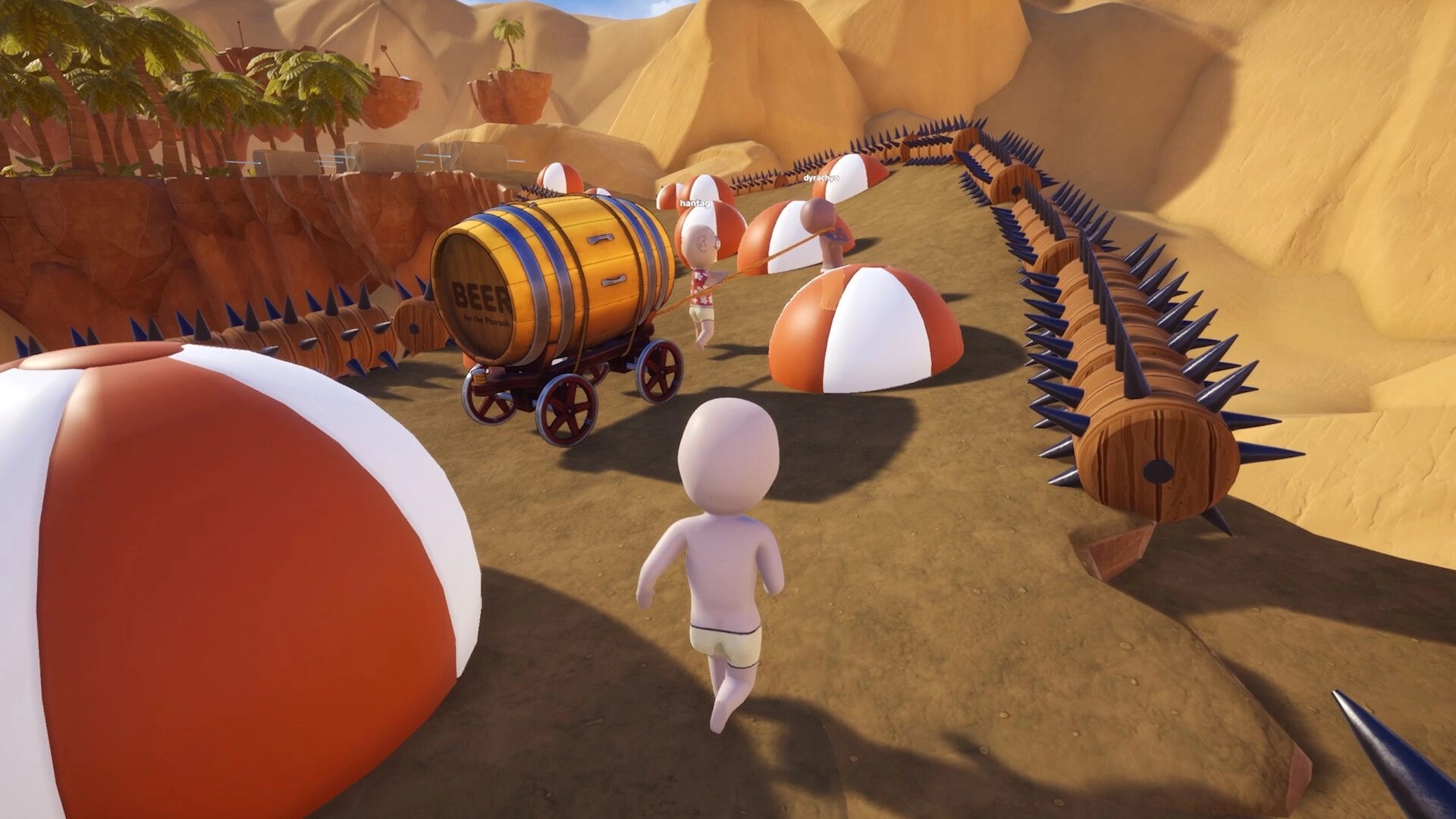 Pull the Beer: Players pull a beer barrel cart through a spiked desert path with beach balls obstacles.