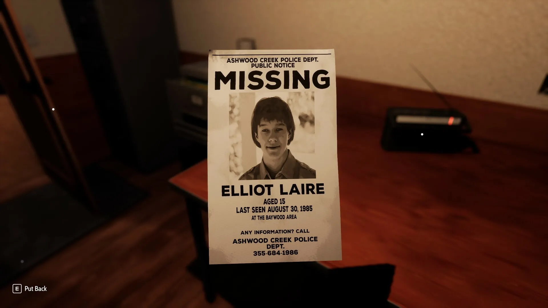 Radiolight: Missing person poster of Elliot Laire on a desk in a dimly lit police station office