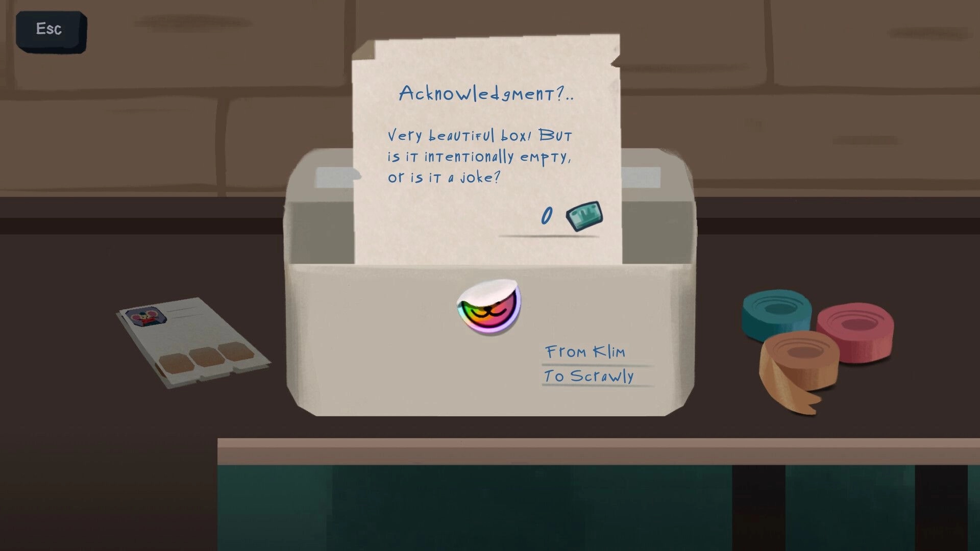 Relocat: Note from Klim questioning empty gift box on table with colorful tape and letter nearby