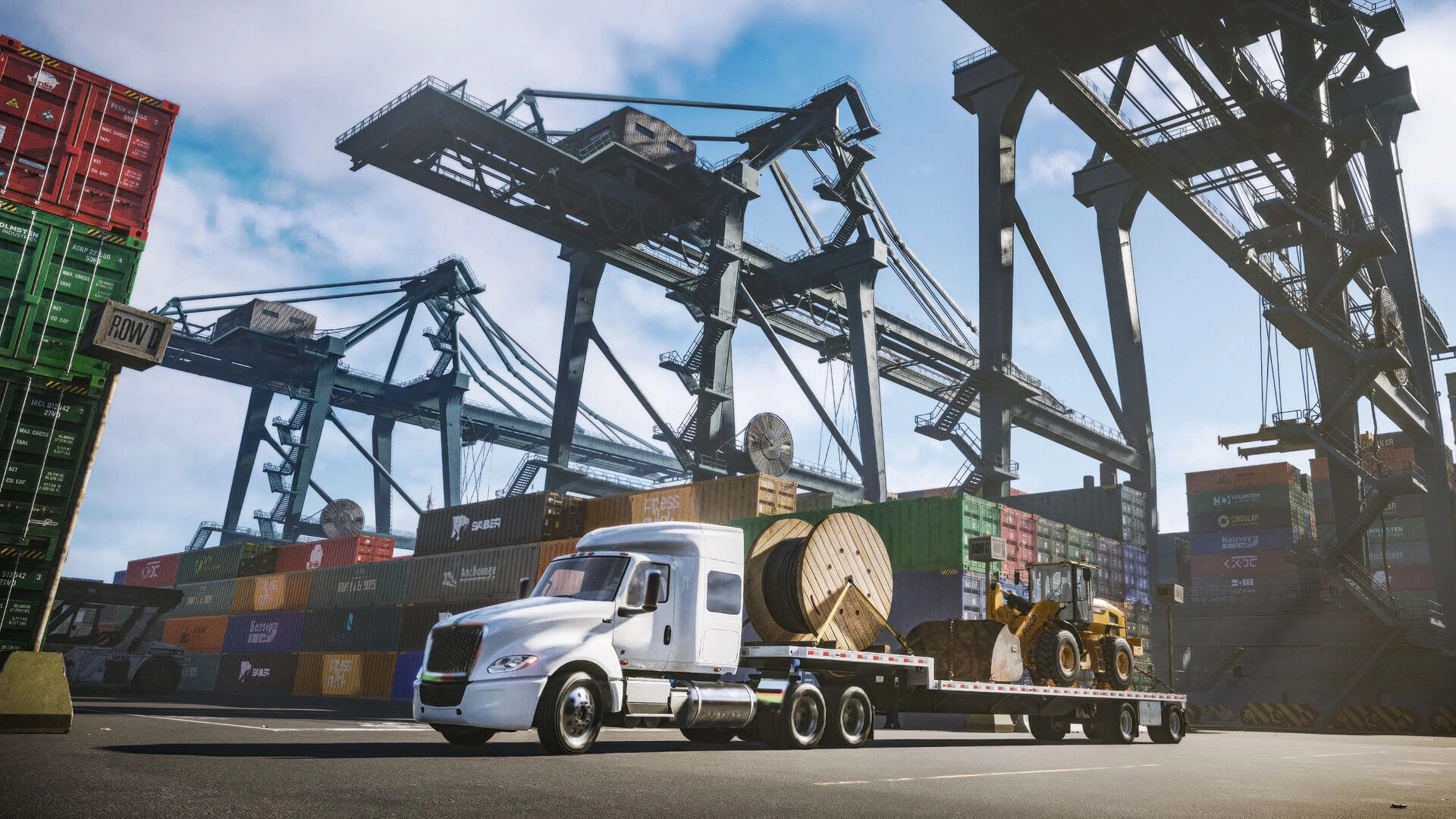 Road Kings: White semi hauling a flatbed with loader and cable spool through a busy container port yard.