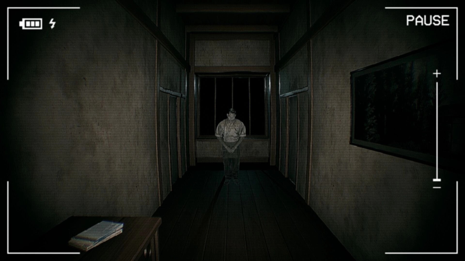 Road to Jukai: First-person camera view of a ghostly man in a dark wooden hallway, pause UI on screen.