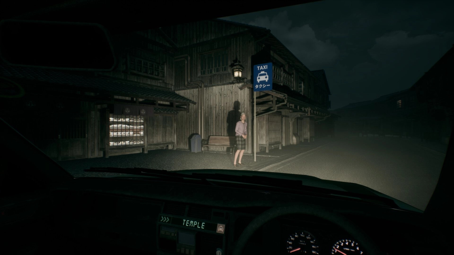 Road to Jukai: Taxi driver views elderly woman at a taxi stop outside wooden buildings at night.