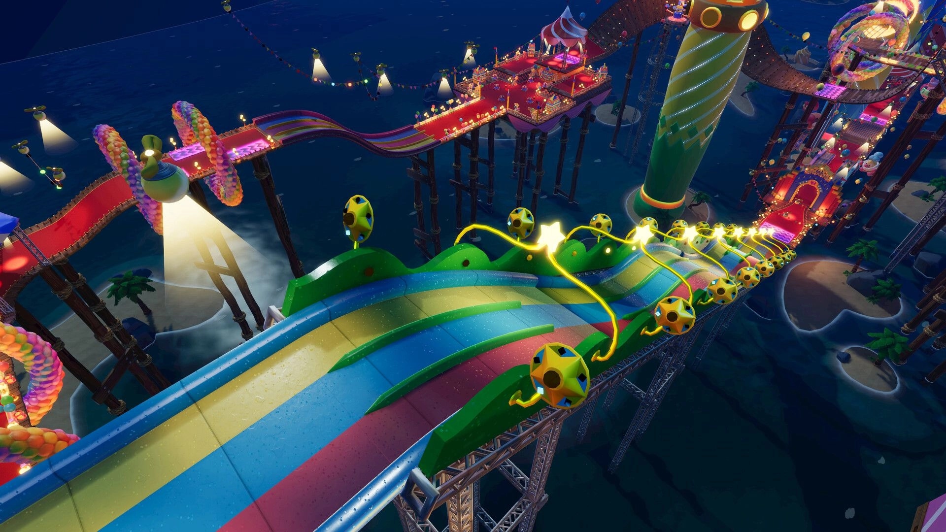 Rollin' Rascal: Rainbow slide track with glowing star pickups and bumpers above a seaside carnival at night.