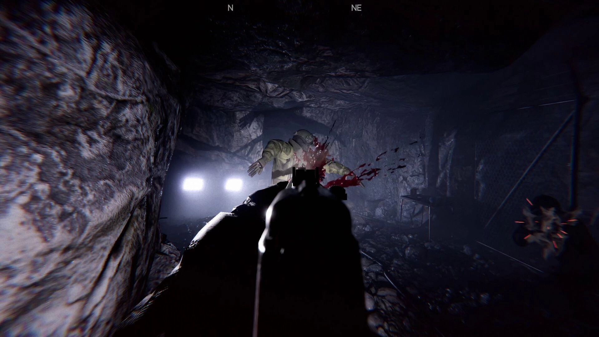 Shadow Project: First-person gunfight in dark cave with enemy in hazmat suit and blood splatter visible