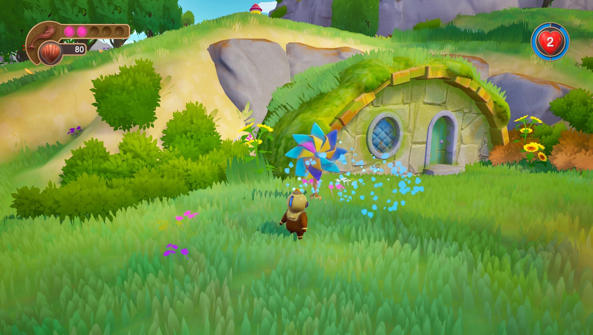 Shallow Pond: Ripples approaches a colorful pinwheel near a grassy, stone-capped house in lush landscape.