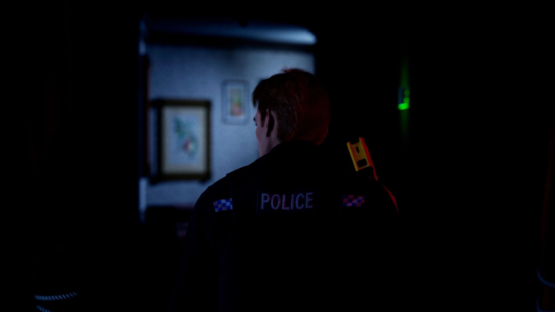 She's Leaving: Police officer exploring dimly lit hallway with framed pictures on the walls