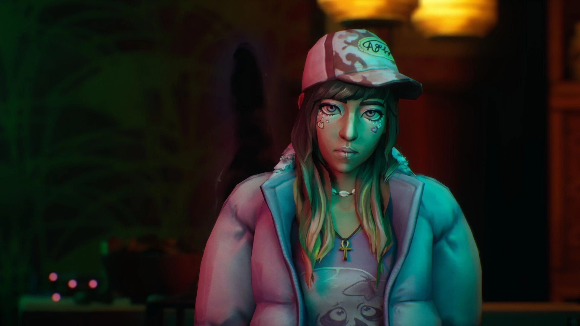 SOMBRAS: Close-up dialogue portrait of Shiomi in cap and hoodie under teal-pink light indoors.